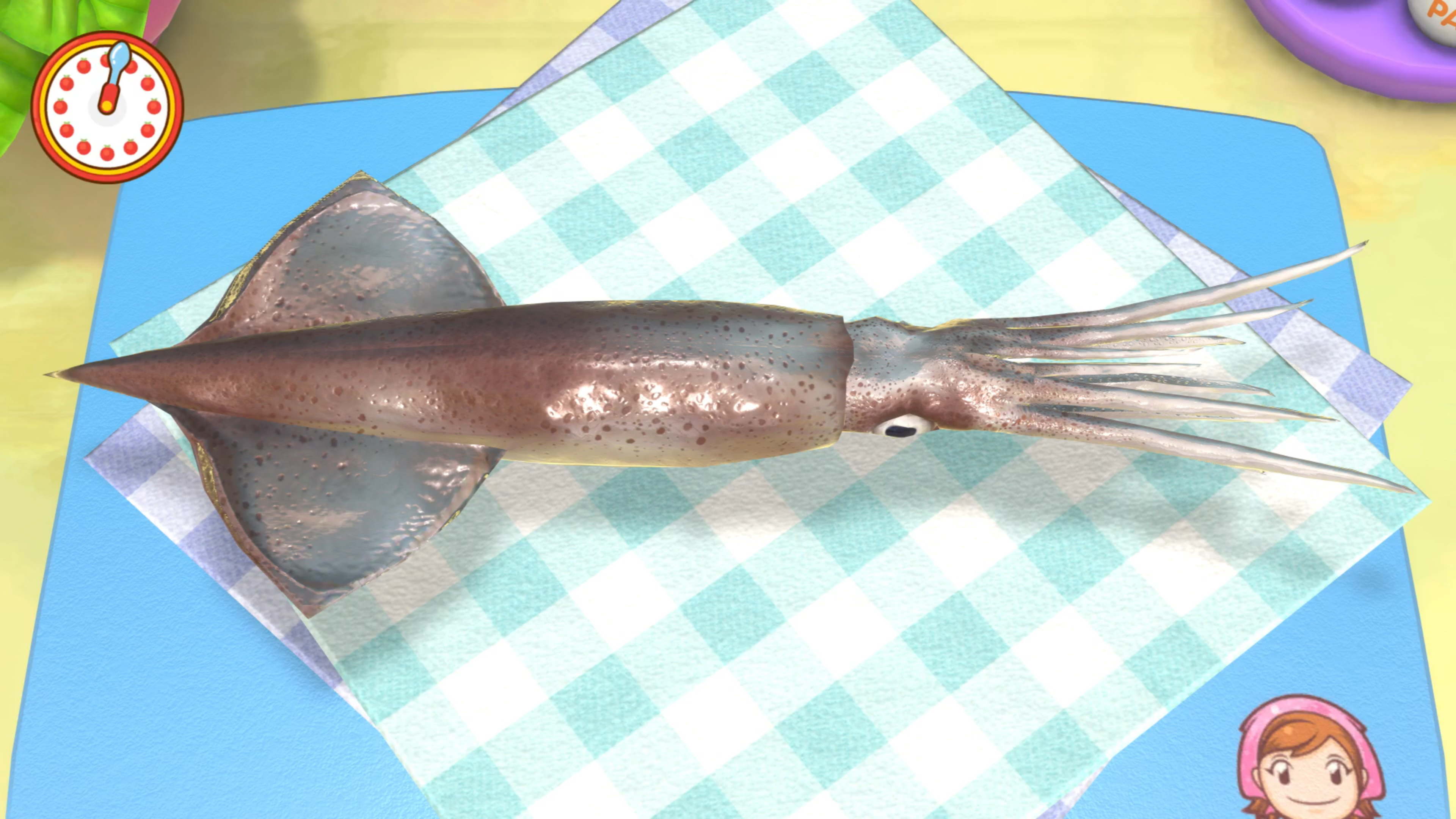 Surowy kalmar na niebieskiej desce do krojenia z kraciastą szmatką.