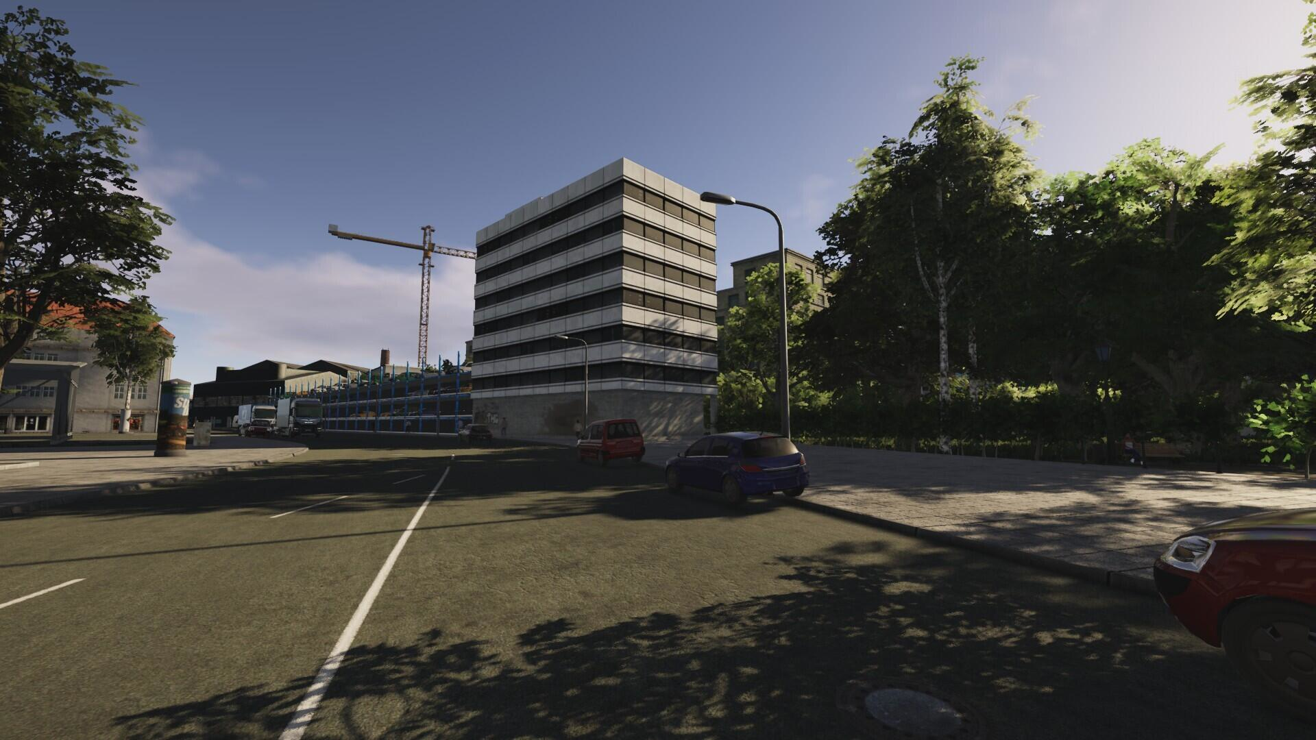 Ulica miejska z samochodami, budynkami i żurawiem budowlanym. Jasne światło słoneczne.