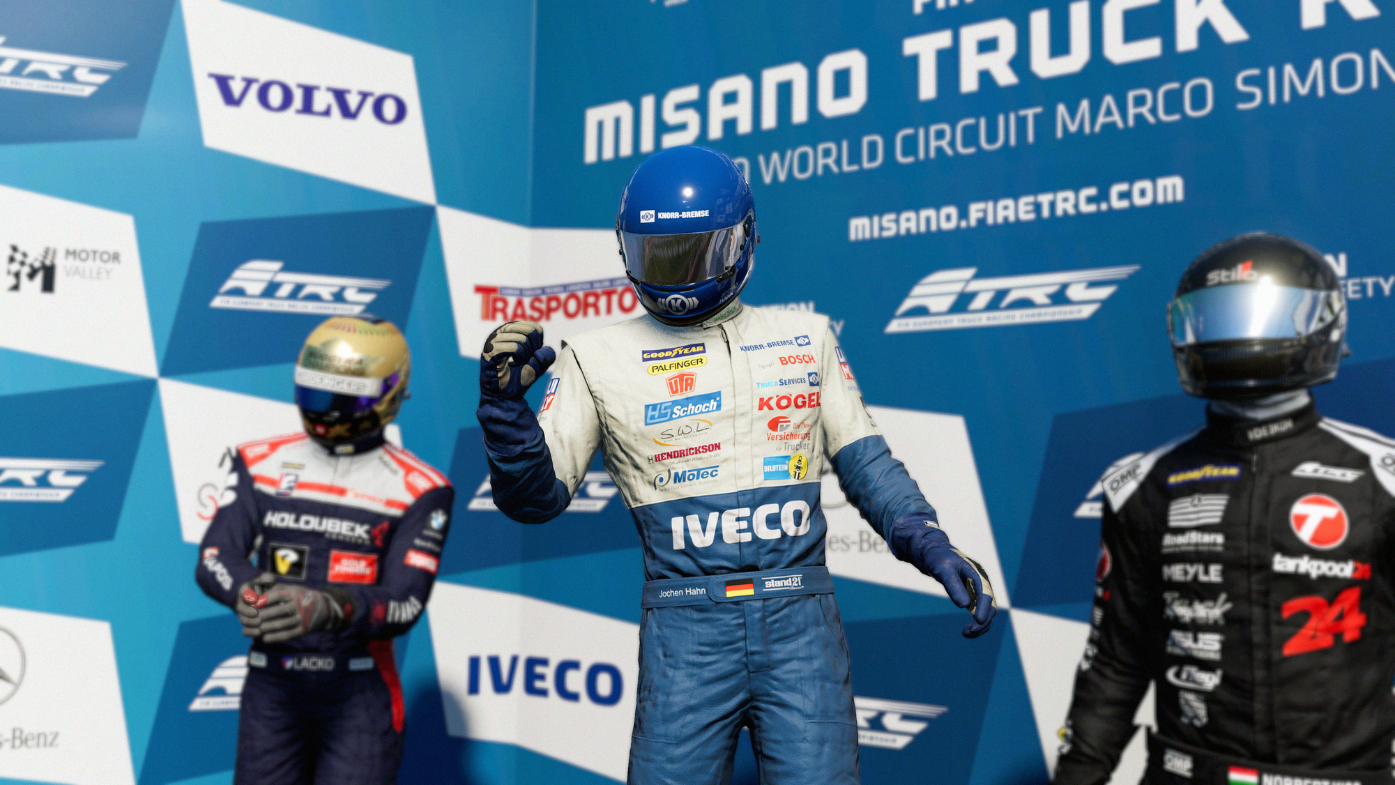 Trzech kierowców wyścigowych na podium. Niebieskie tło z logo sponsorów.