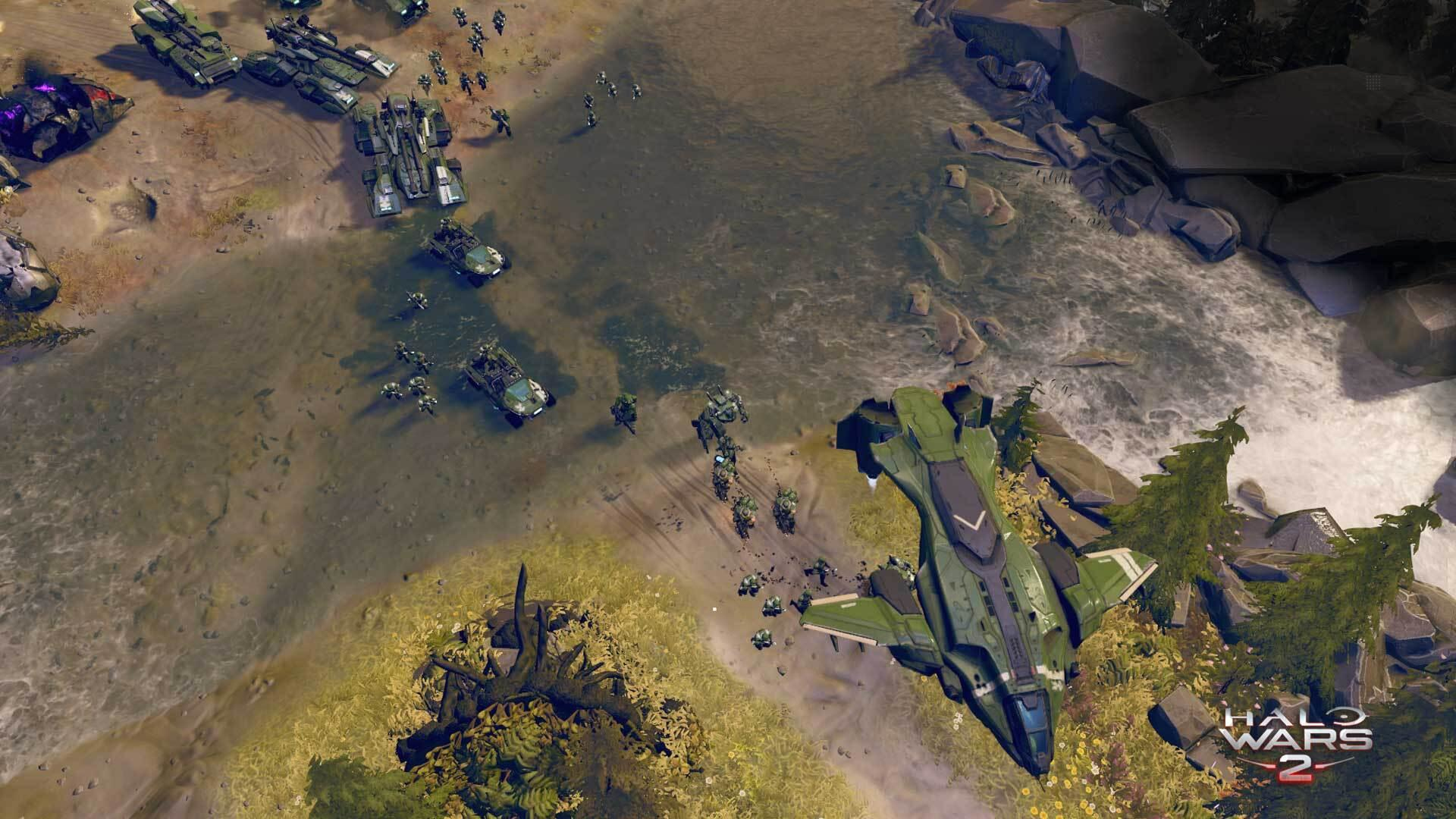 Draufsicht auf eine Halo Wars 2 Szene. Militärfahrzeuge und Soldaten am Strand mit einem großen Schiff.