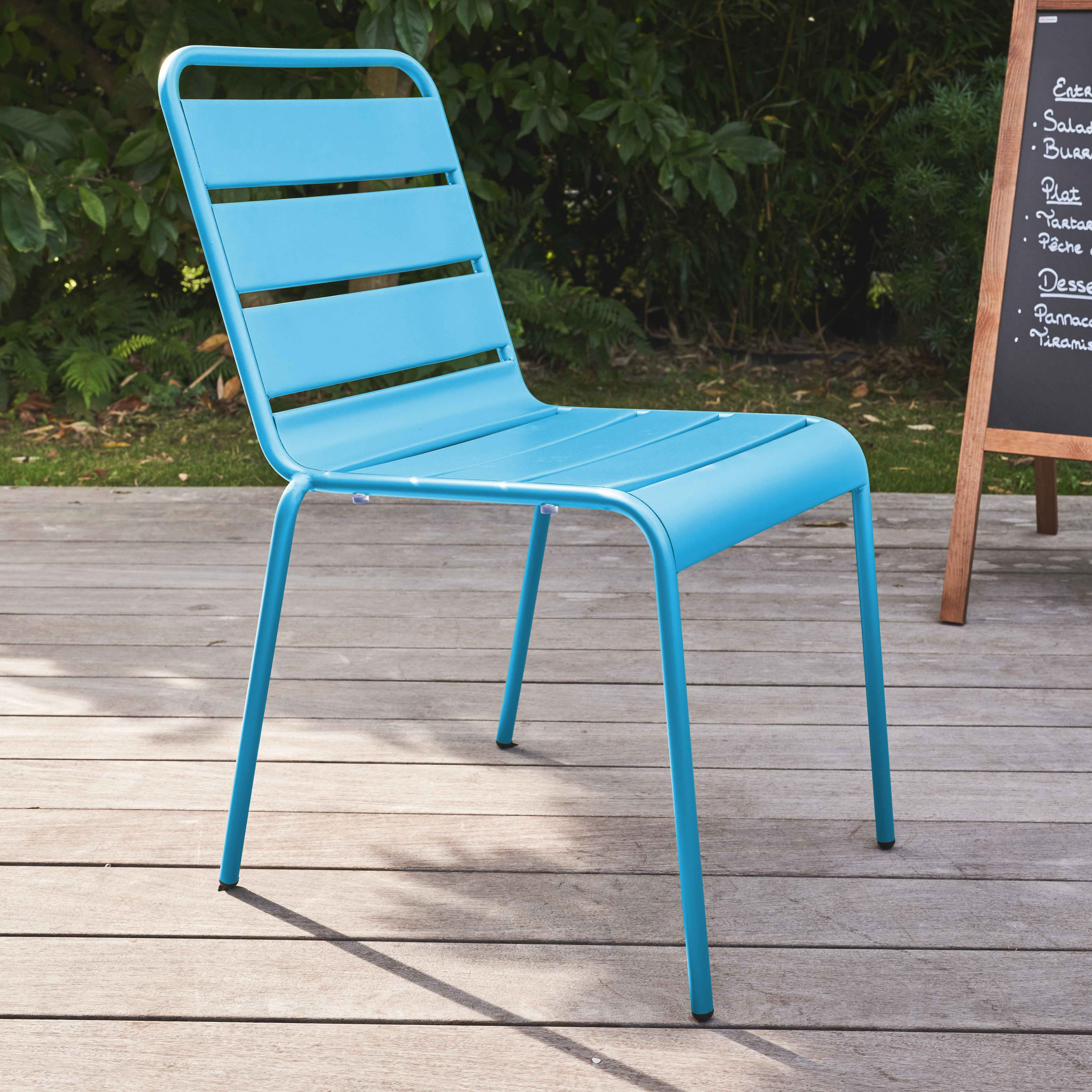 Blauer Stuhl im Freien auf Holzterrasse neben einer Tafel mit Menüpunkten.
