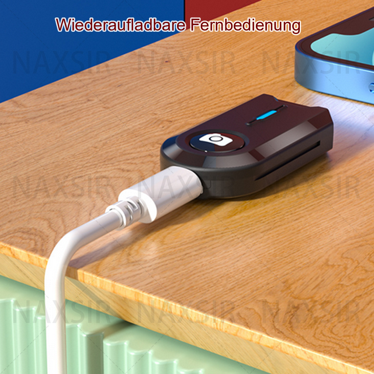 Schwarze Fernbedienung mit Knopf, weißes Kabel, auf Holzoberfläche.