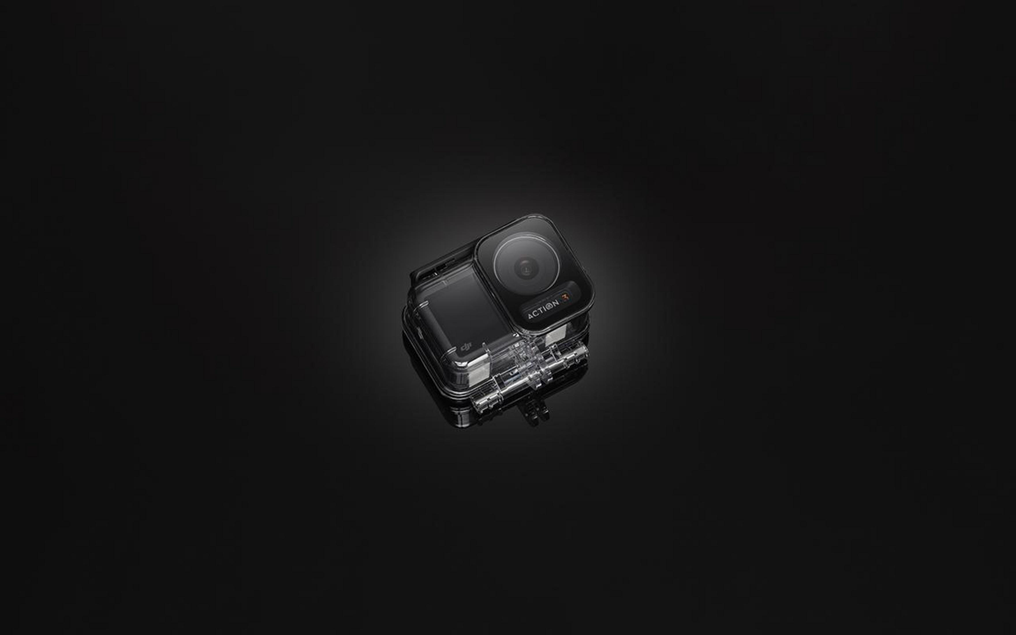 Czarna kamera sportowa w wodoodpornej obudowie na czarnym tle z odbiciem.