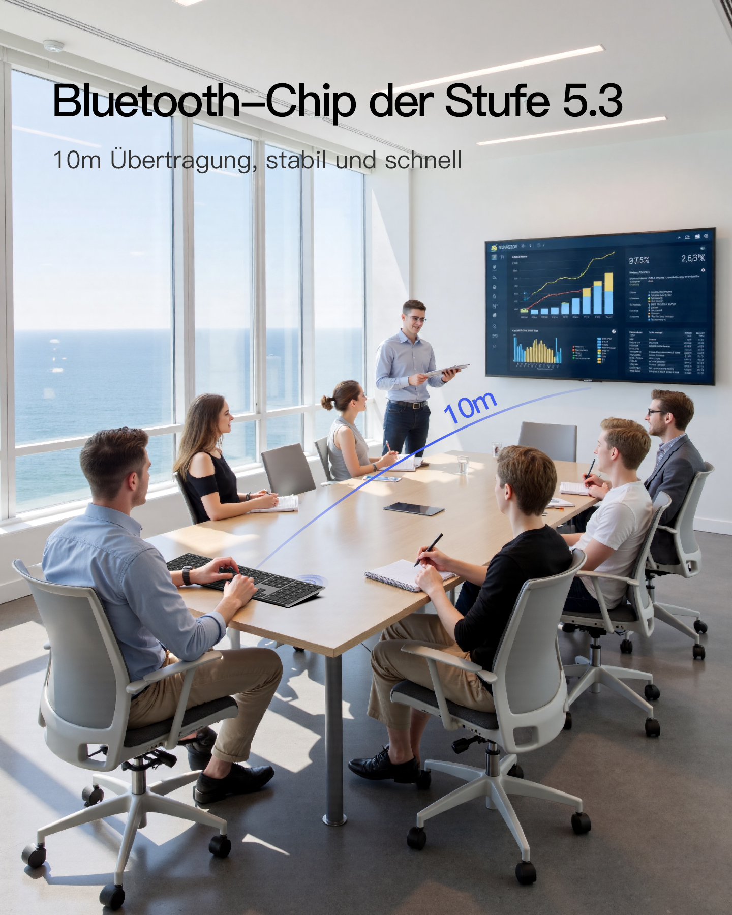 Personen in einem Büromeeting, mit einem Mann, der Daten auf einem großen Bildschirm präsentiert, Tastatur davor.