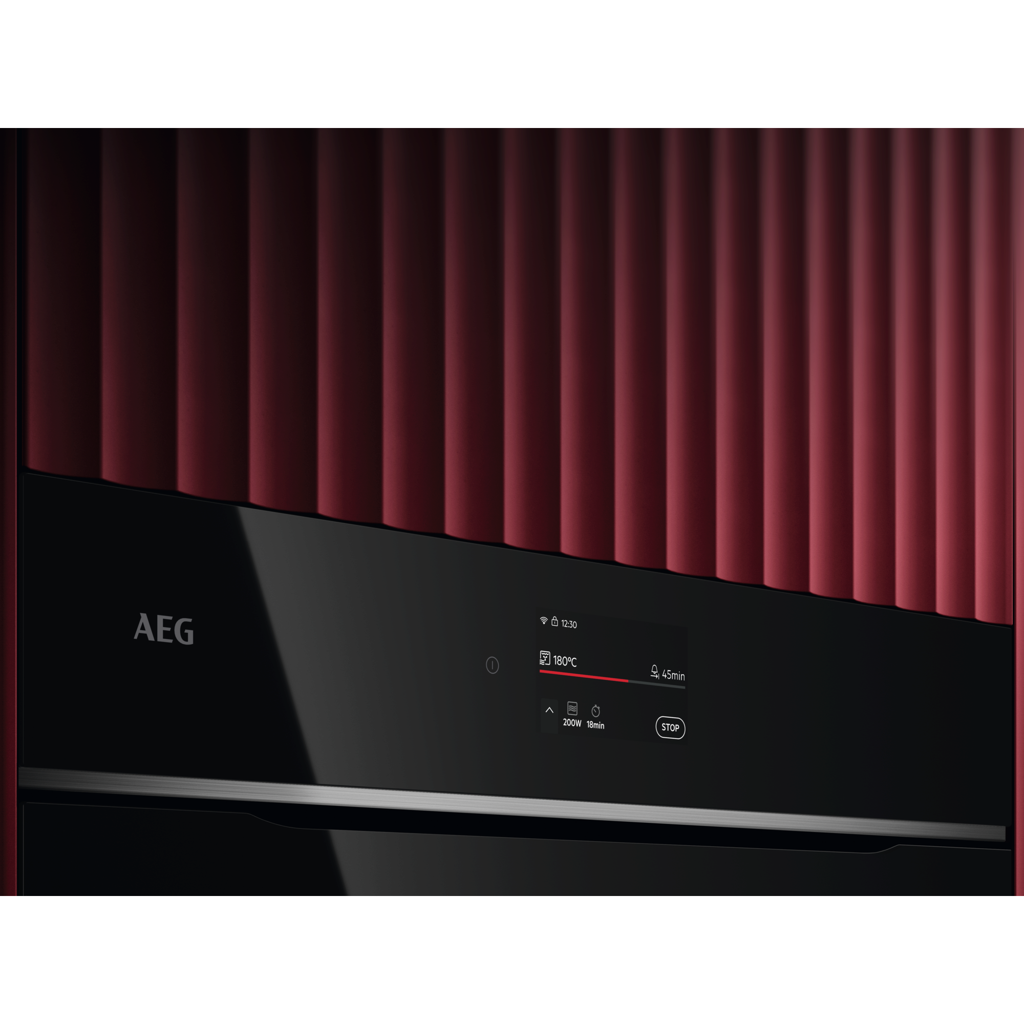 Horno negro con pared roja texturizada. Logotipo de AEG visible.