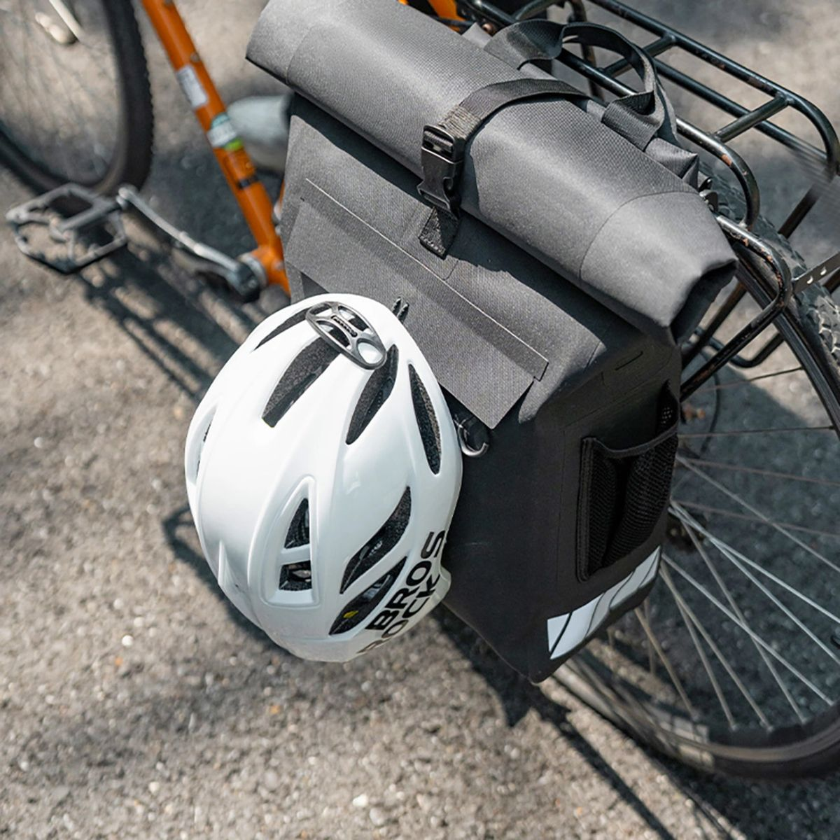 Ein Fahrrad mit schwarzer Tasche und weißem Helm.