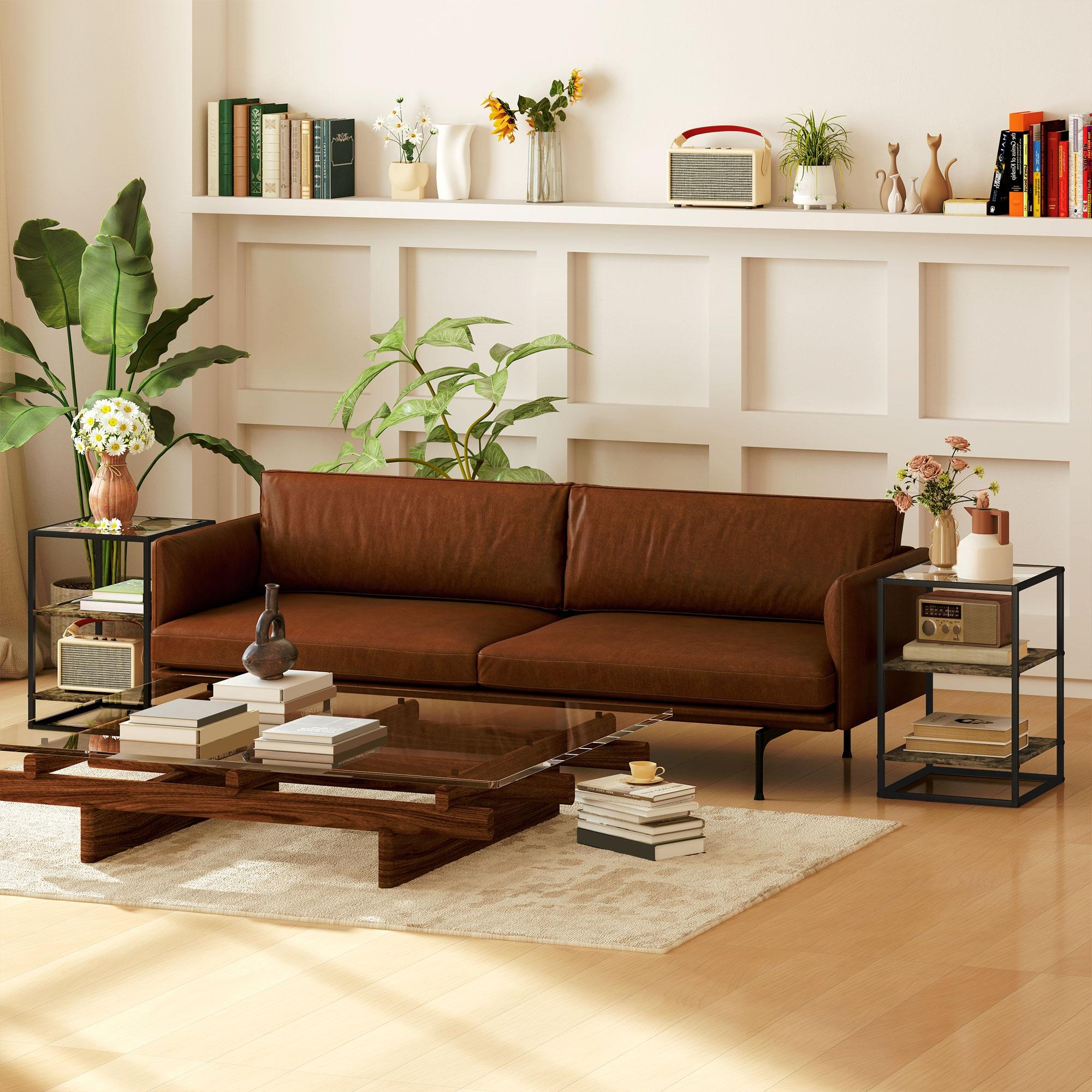 Ein Wohnzimmer mit einem braunen Sofa, einem Couchtisch, zwei Beistelltischen, Büchern, Blumen und einem Radio.