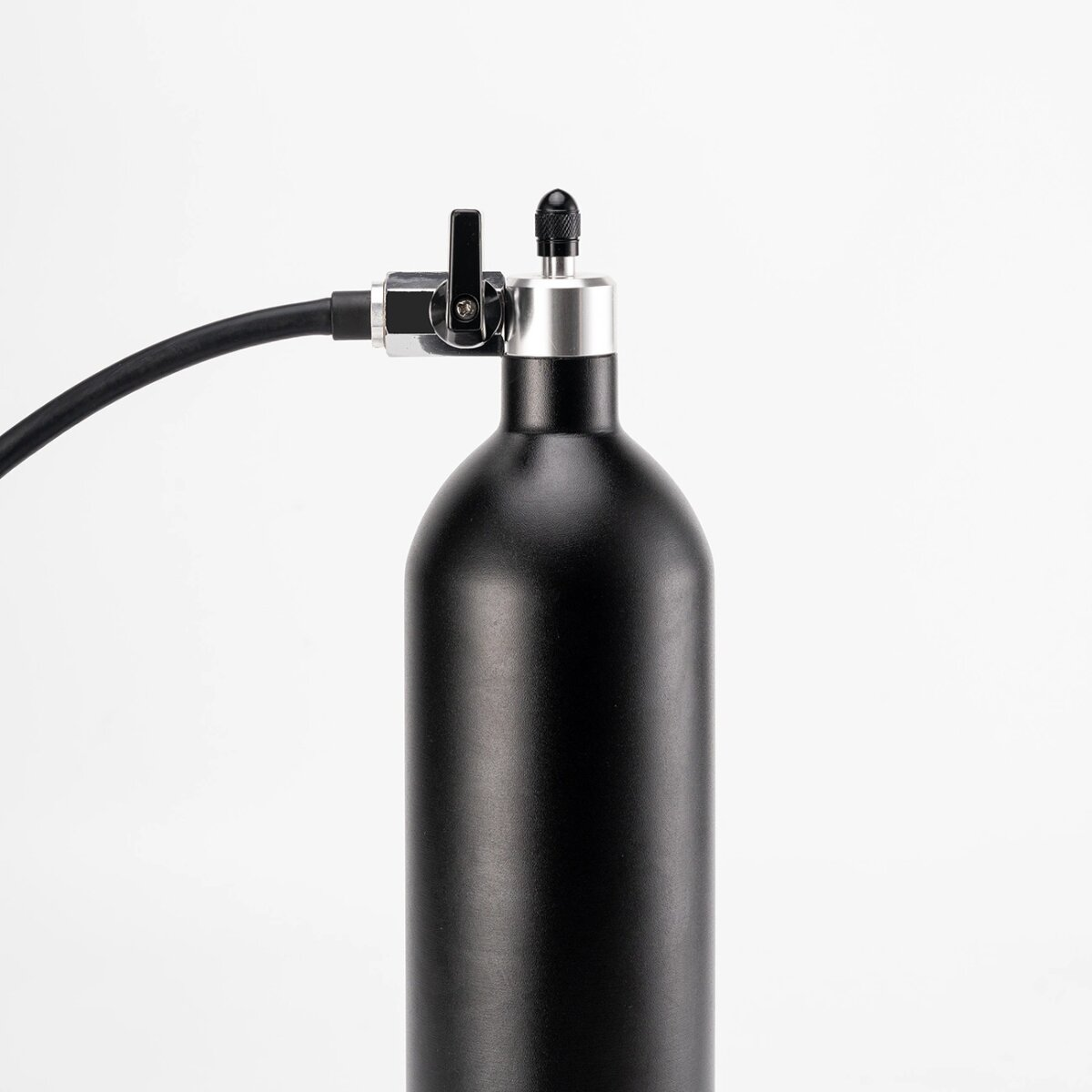 Schwarze Flasche mit Schlauch und Düse. Weißer Hintergrund.