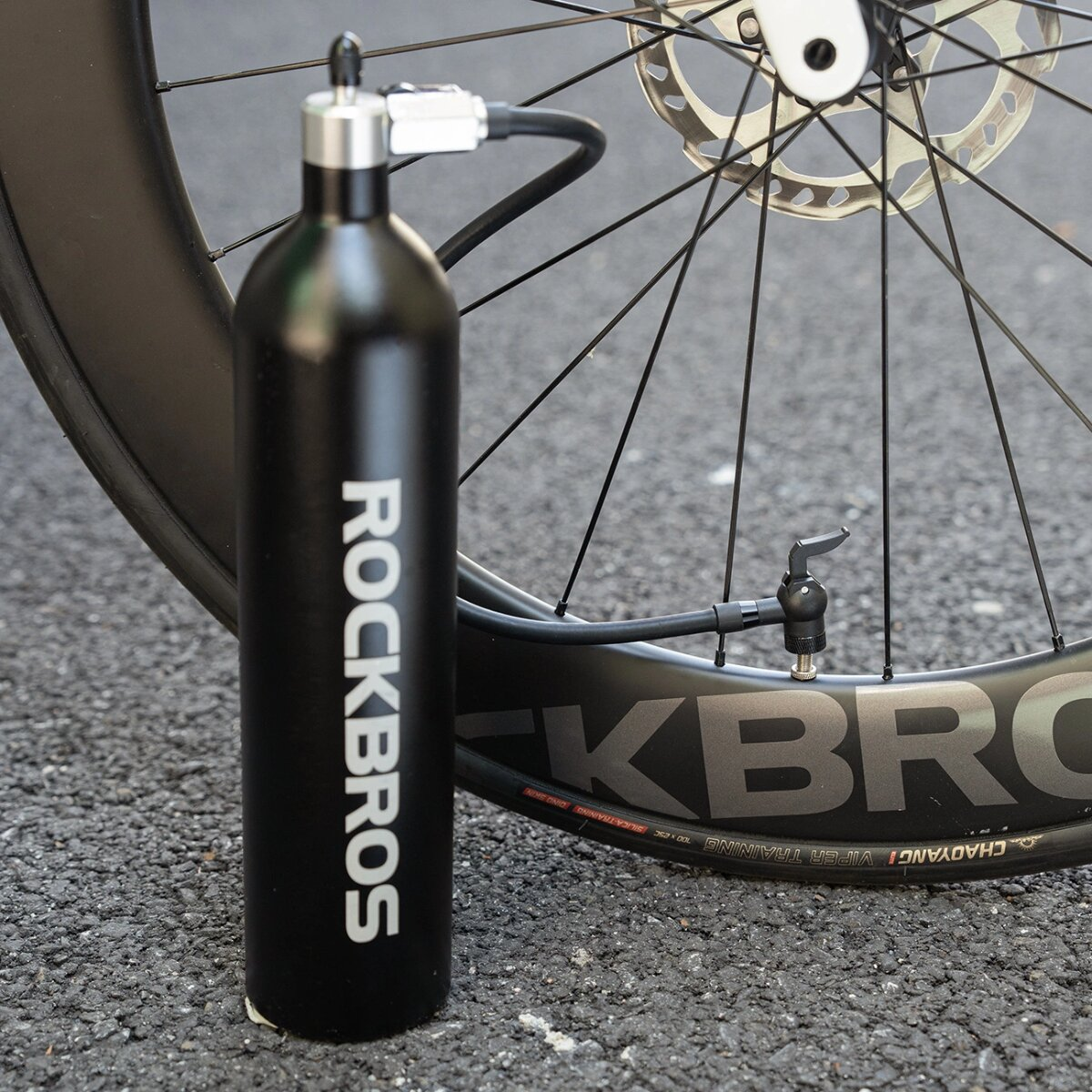 Schwarze Fahrradpumpe neben einem Rad. Auf der Pumpe steht "ROCKBROS".