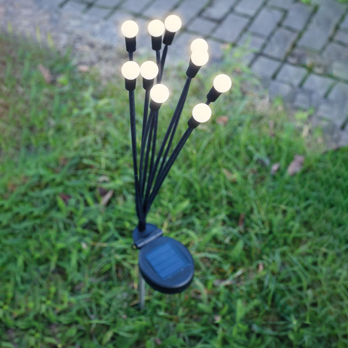 Solarbetriebene Gartenlichter, mit mehreren kleinen weißen Lichtern an schwarzen Stielen.