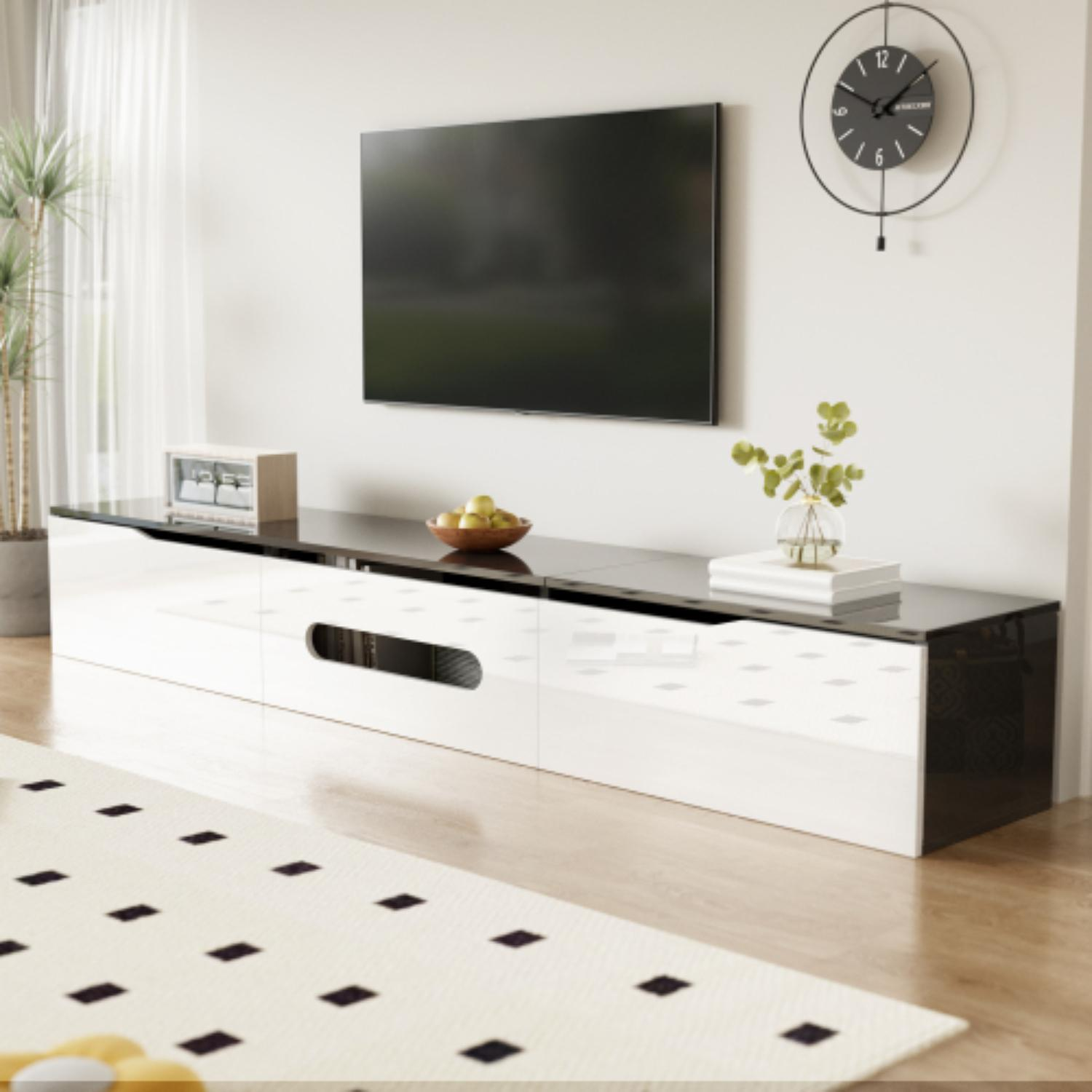 Ein moderner weißer TV-Ständer mit schwarzer Oberseite. Ein Fernseher ist an der Wand montiert, und es gibt einen Teppich.