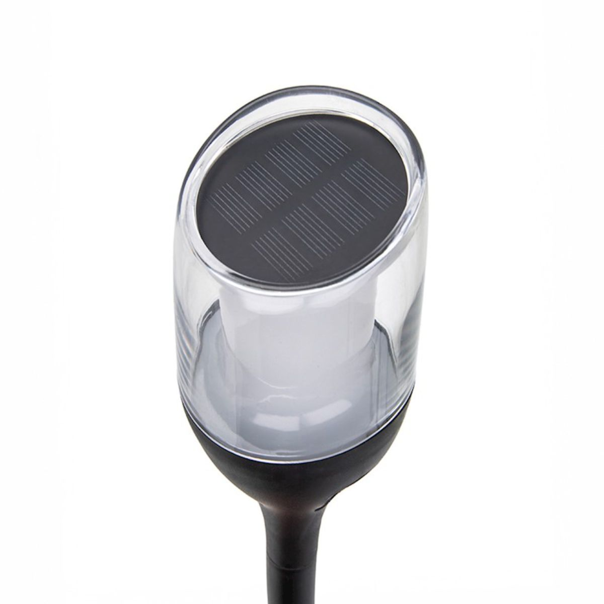 Une lampe solaire de jardin avec un dessus en plastique transparent. Elle a une base sombre.