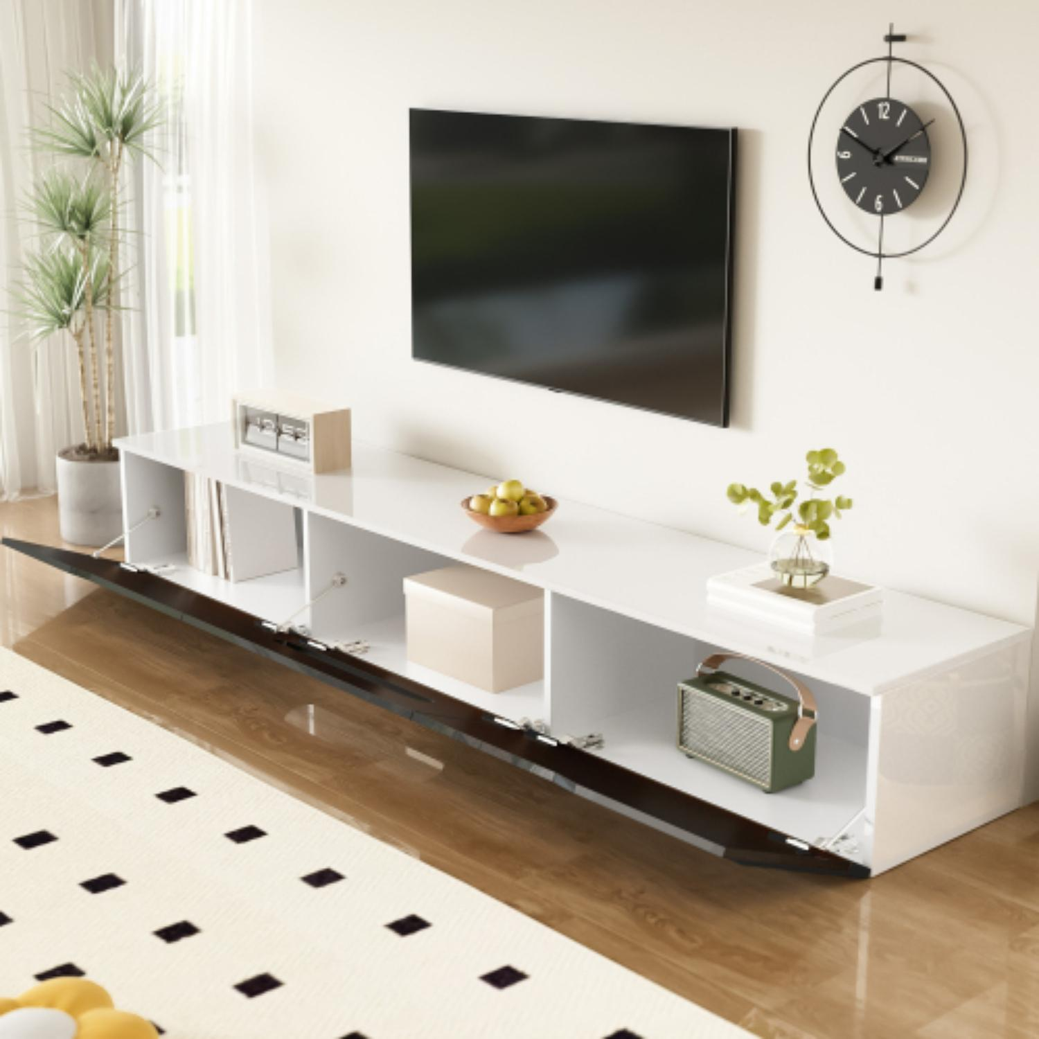 Ein Wohnzimmer mit weißem und schwarzem TV-Ständer, Fernseher, Uhr und Deko.