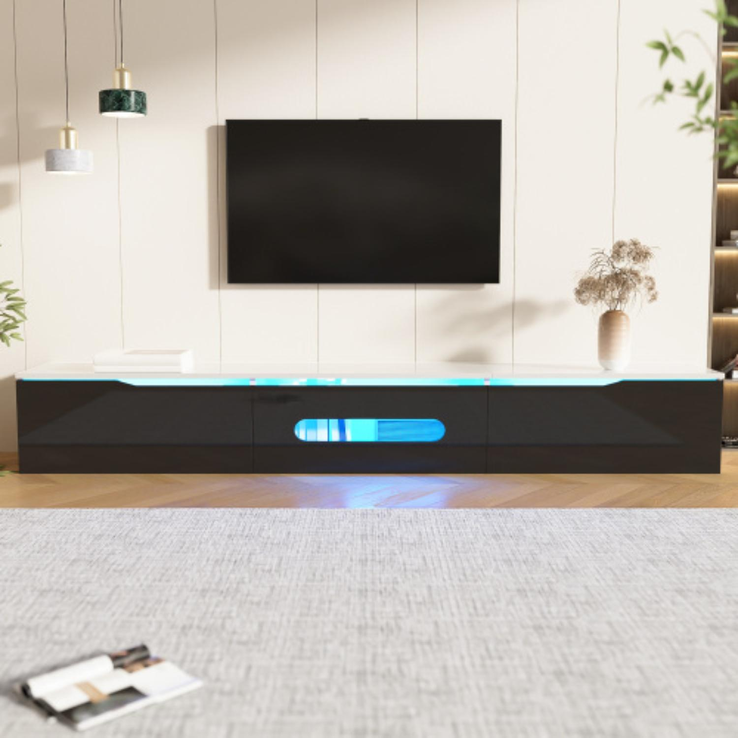 Ein Wohnzimmer mit schwarzem TV-Ständer, Fernseher und verschiedenen Dekorelementen.