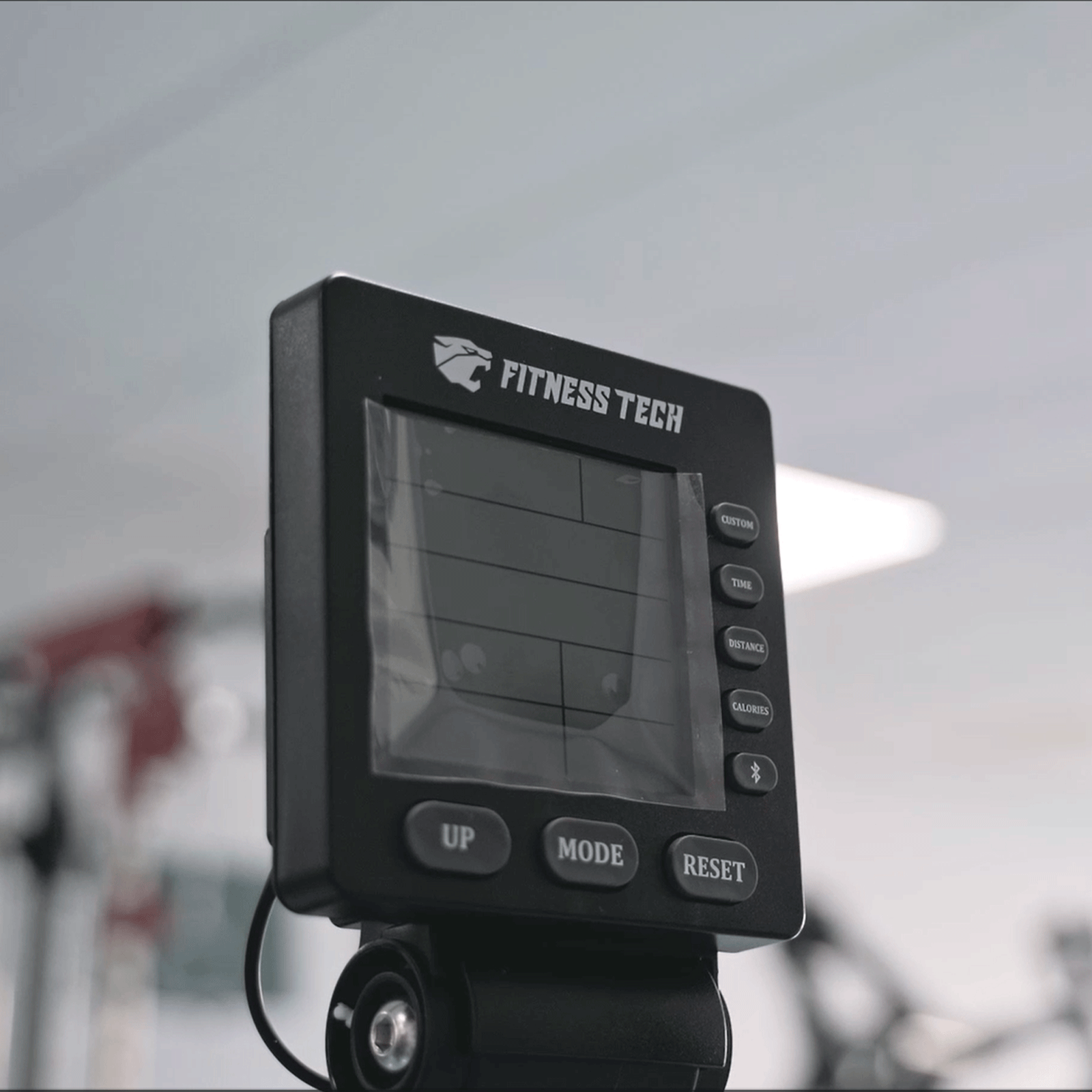 Display nero della macchina fitness che mostra 'FITNESS TECH' e metriche.