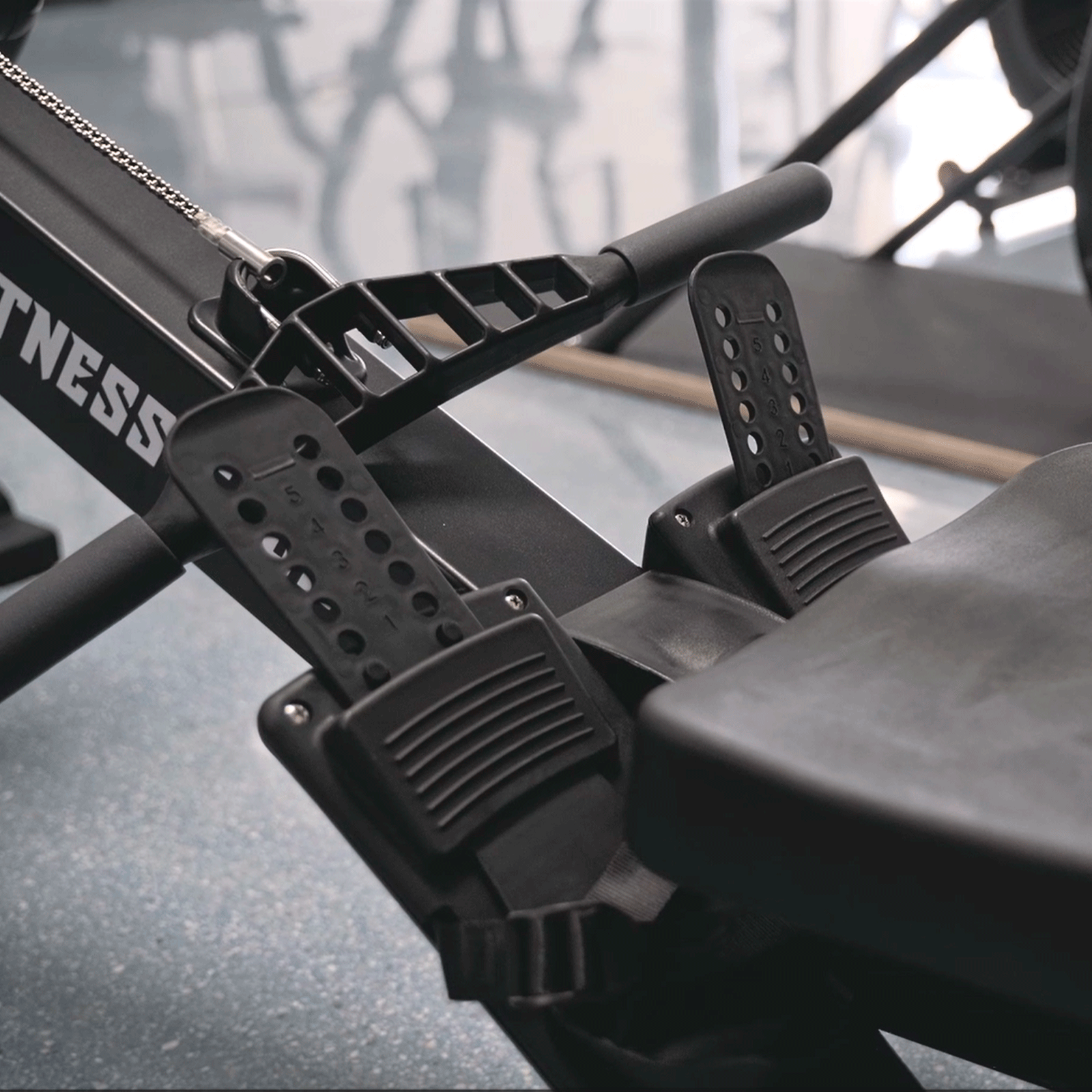 Macchina per il canottaggio nera con poggiapiedi numerati. Logo Fitness Tech visibile.