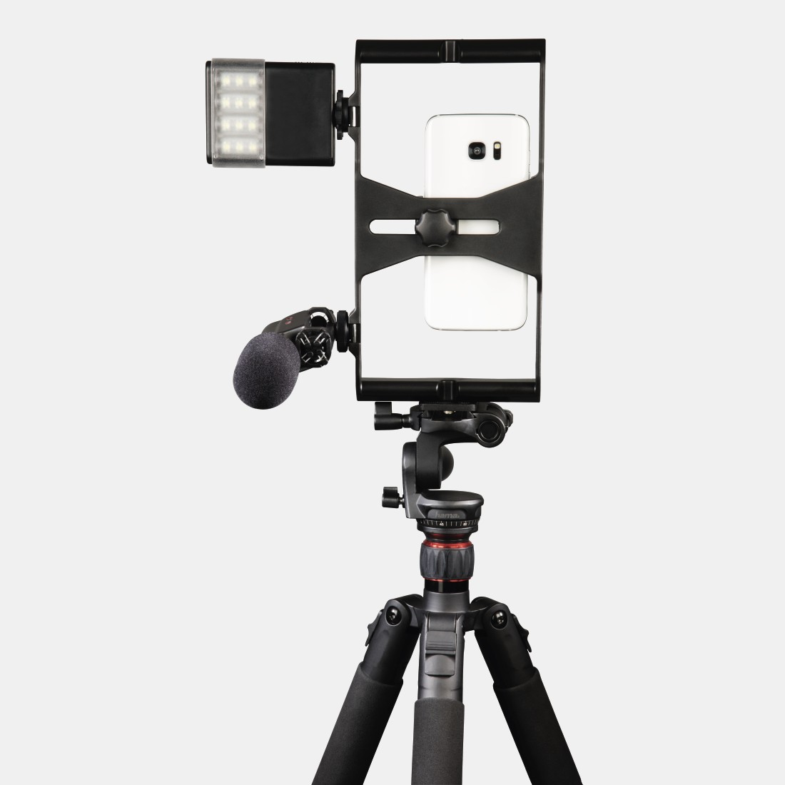 Smartphone montato su treppiede con luce e microfono. Sfondo bianco.