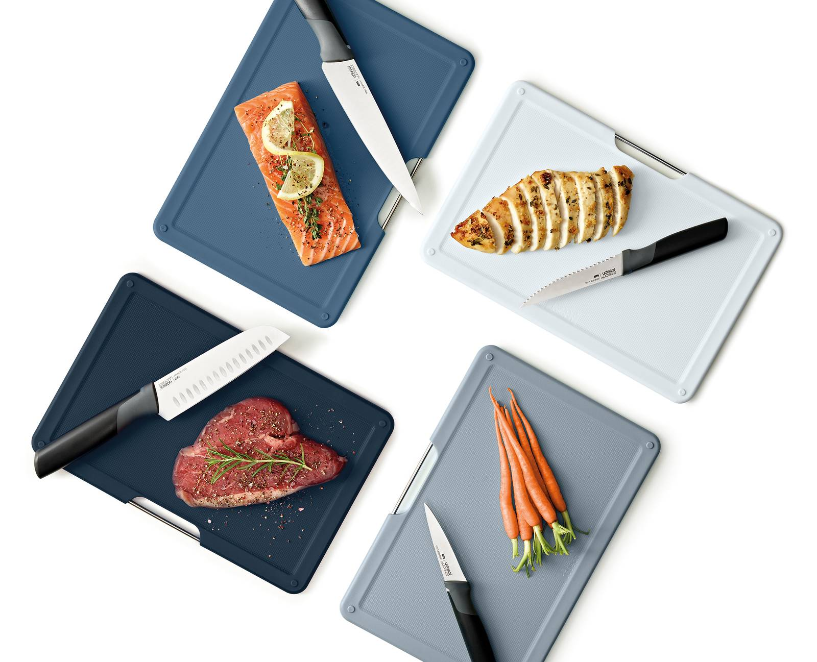 Schneidebretter mit zubereiteten Speisen. Lachs mit Zitrone, Hähnchen in Scheiben, Steak, Karotten.