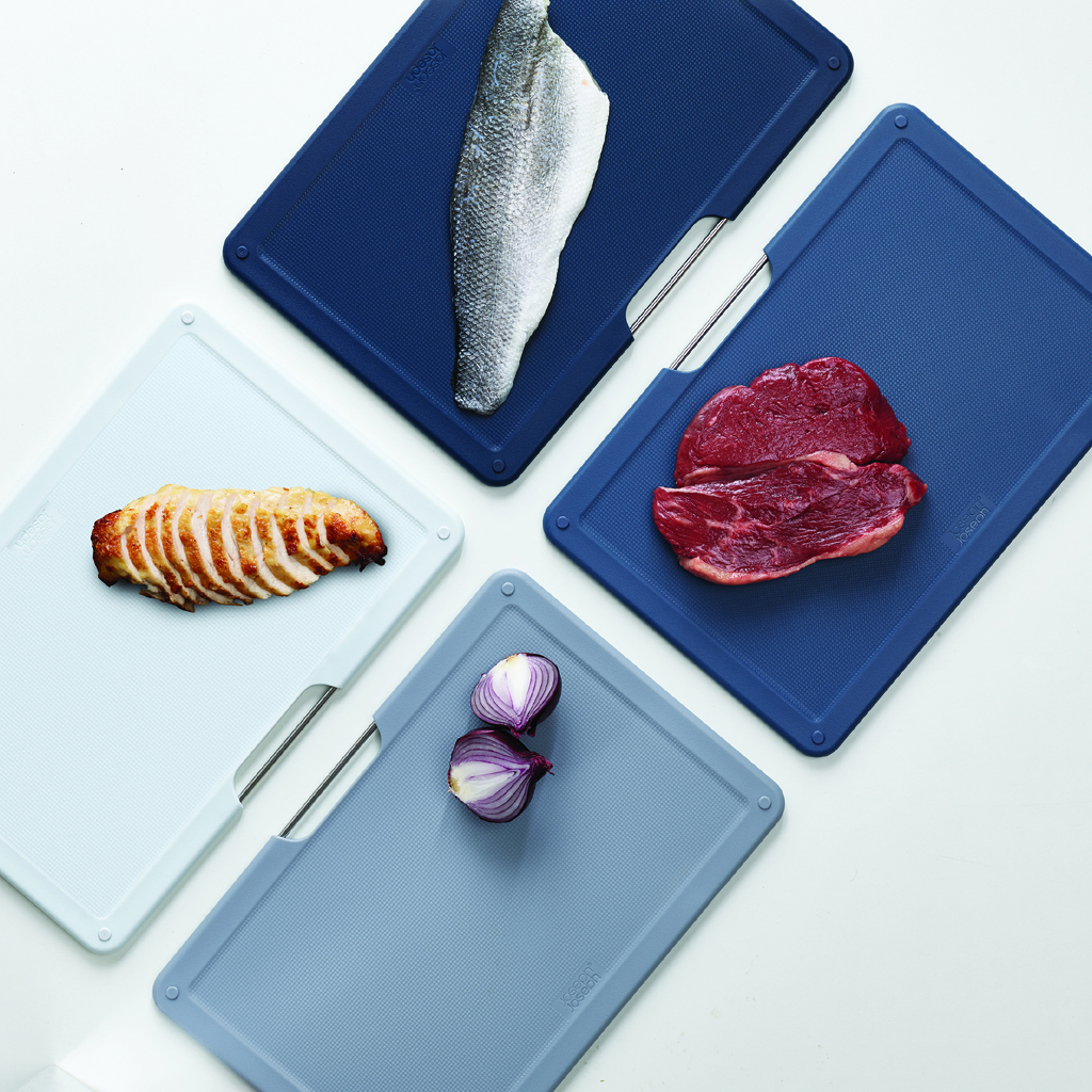Set von Schneidebrettern mit Lebensmitteln: Fisch, Fleisch, Zwiebeln und Huhn.