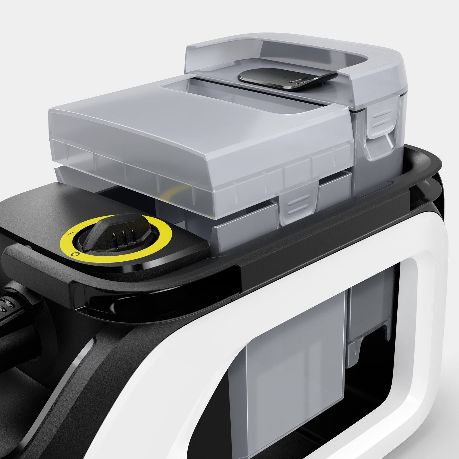 Zbliżenie czarno-białej maszyny czyszczącej z szarą górą, żółtym pokrętłem i przezroczystymi pojemnikami.