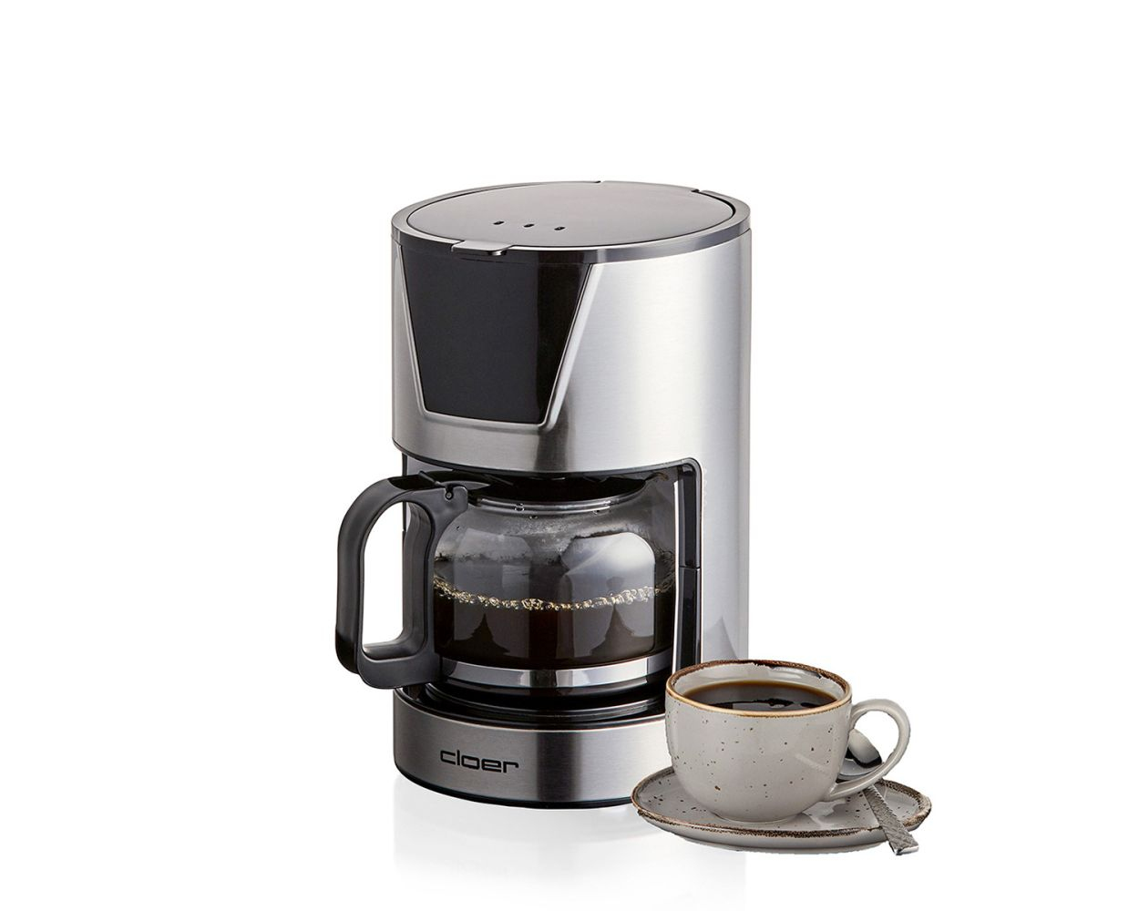 Srebrny ekspres do kawy ze szklaną karafką i filiżanką kawy na spodku.