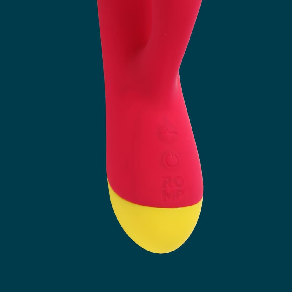 Zbliżenie czerwono-żółtej zabawki erotycznej na niebieskim tle.