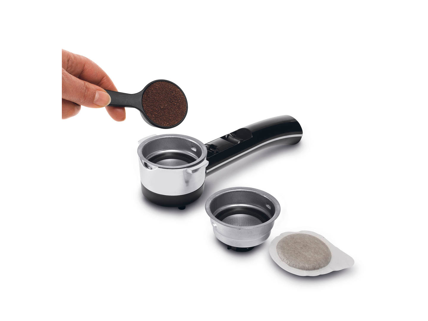 Ręka wsypująca zmieloną kawę do uchwytu filtra ekspresu do kawy.