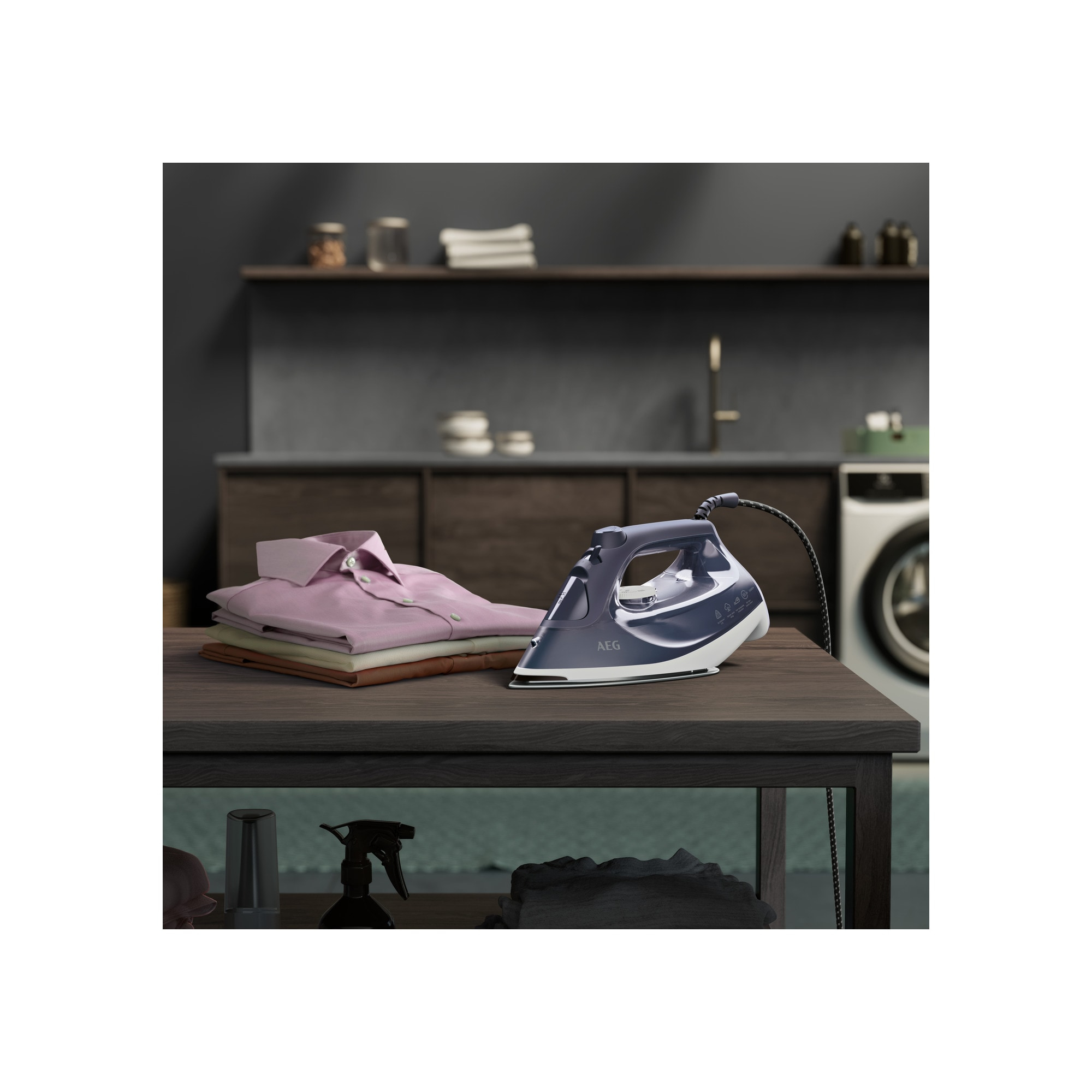 Żelazko AEG i stos złożonych różowych koszul na drewnianym stole w pralni.