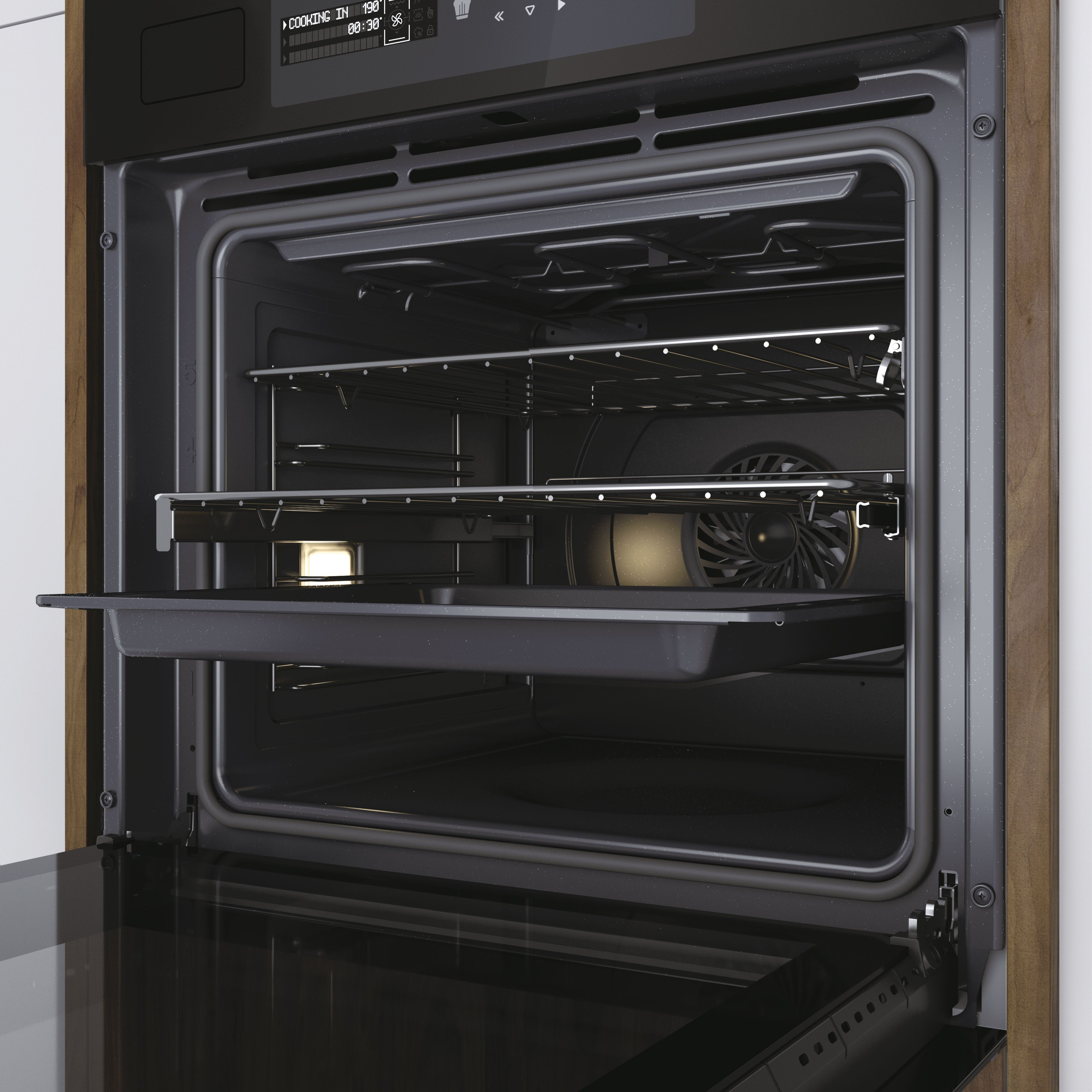 Un horno abierto con una bandeja dentro. Tiene un ventilador y una luz encendida.