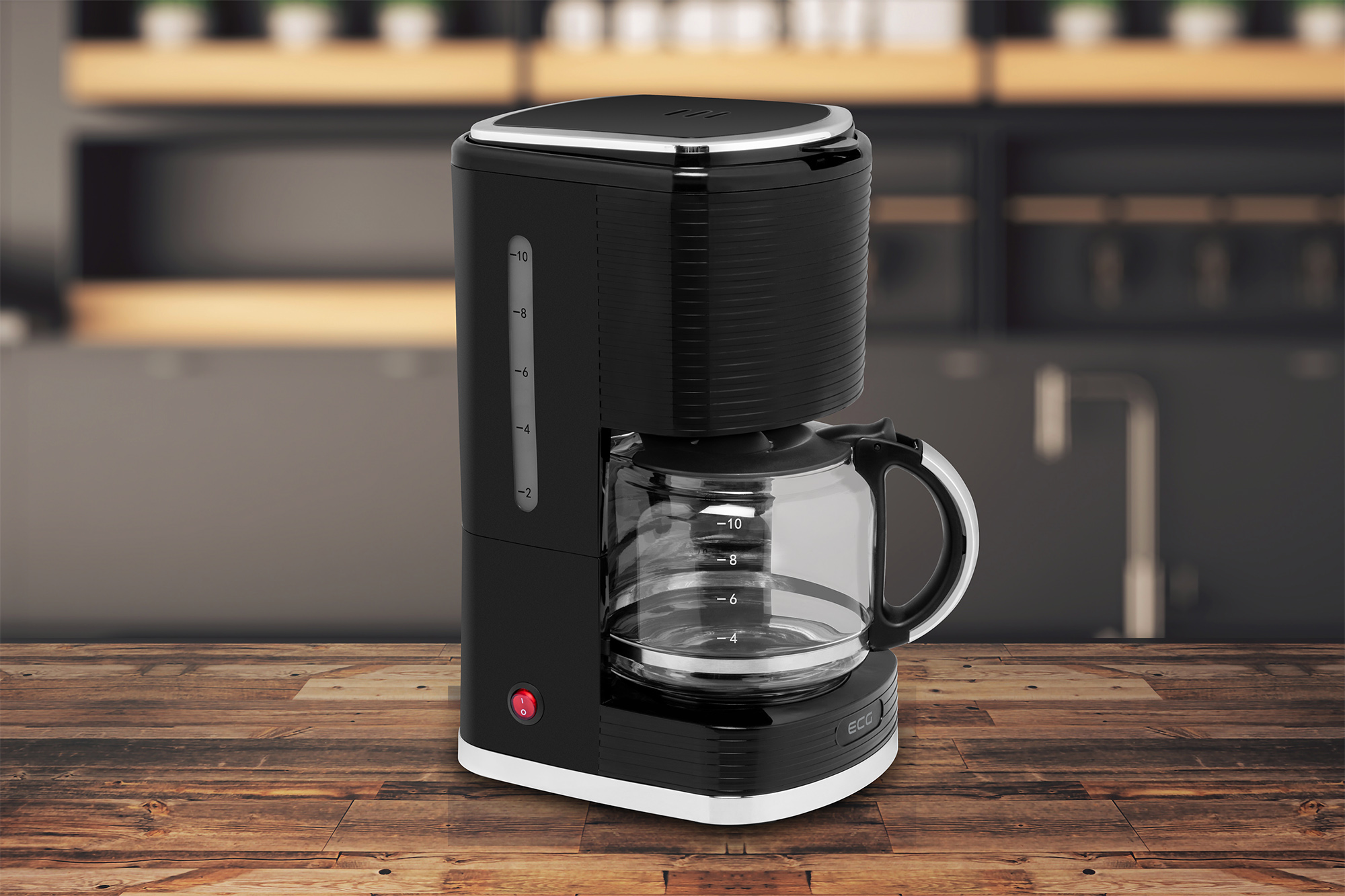 Czarny ekspres do kawy na drewnianej powierzchni. Szklana karafka z kawą. Rozmyte tło.