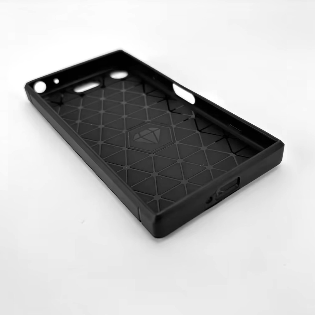 Schwarze Handyhülle, Innenansicht. Diamantenmuster. Die Hülle ist für ein Telefon.