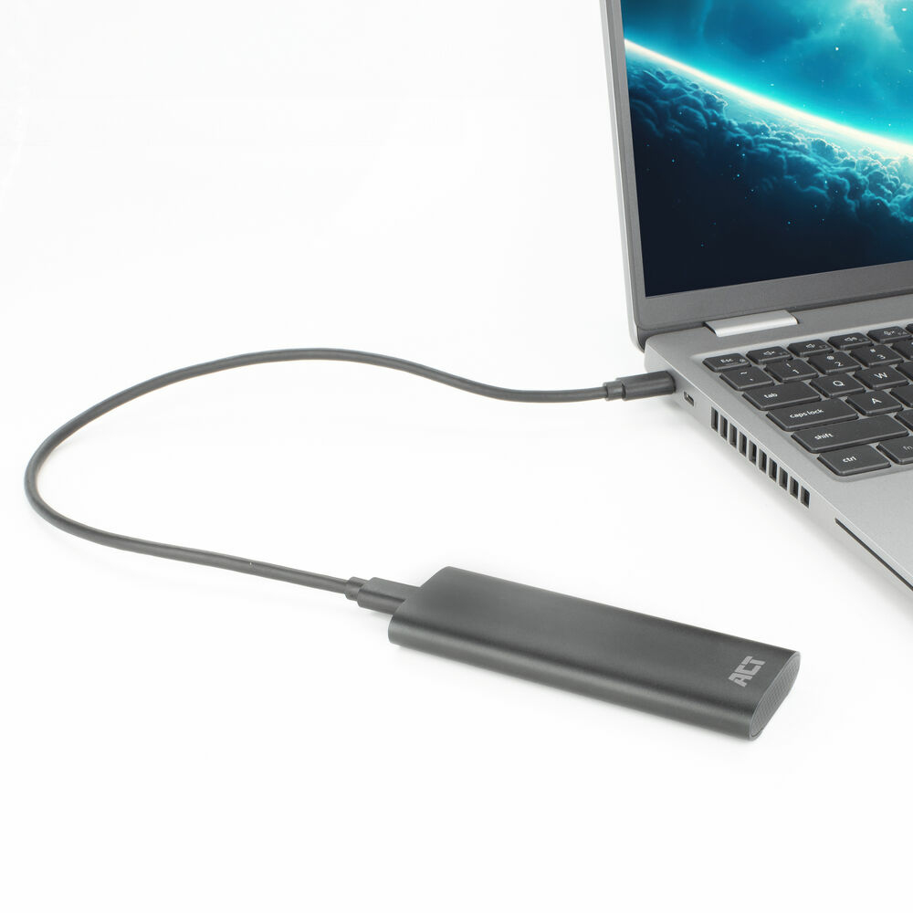 Laptop, der an eine schwarze externe Festplatte angeschlossen ist. Der Laptop steht auf einer weißen Oberfläche.
