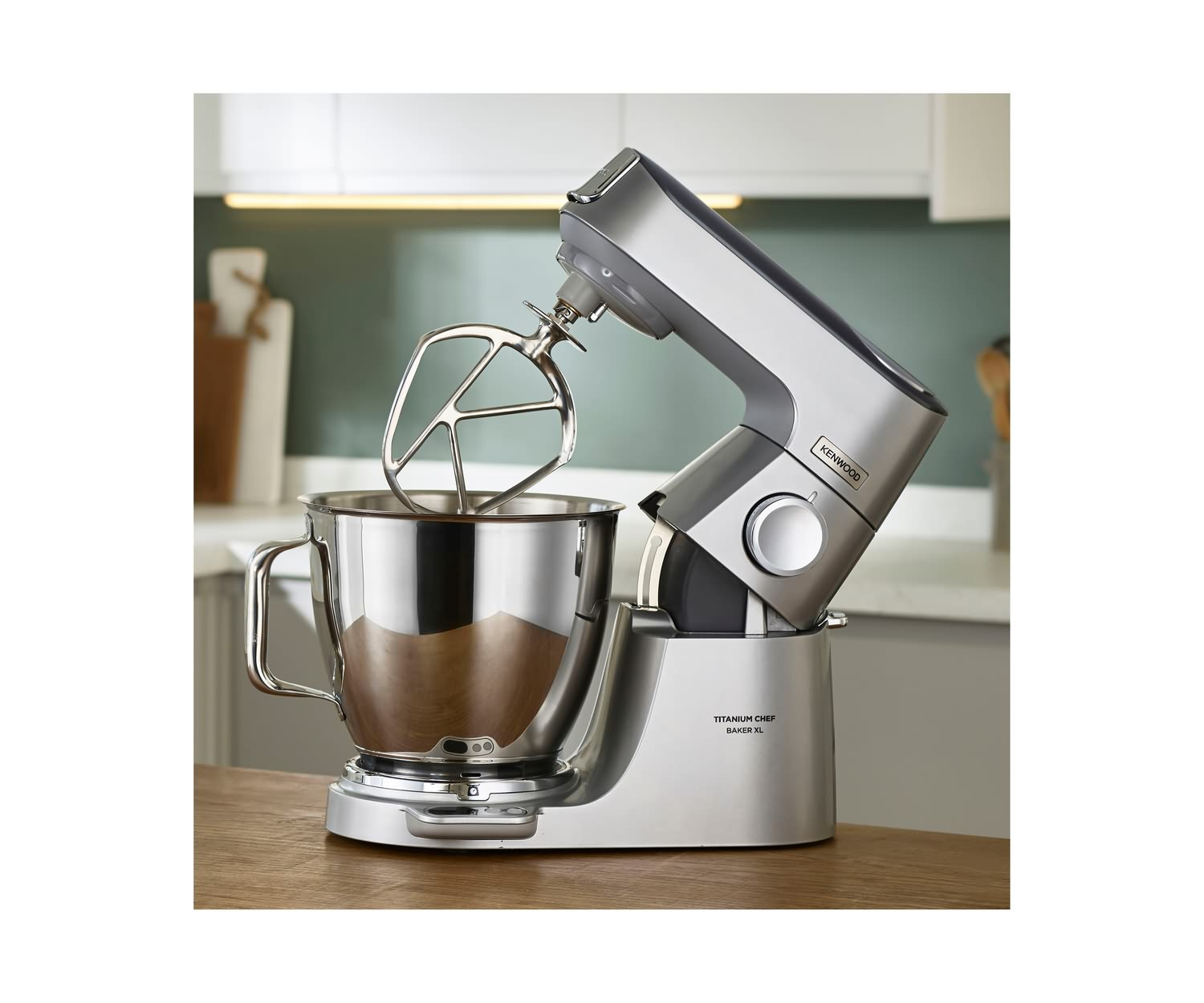 Silberner Kenwood Küchenmixer mit Schüssel und Aufsätzen.