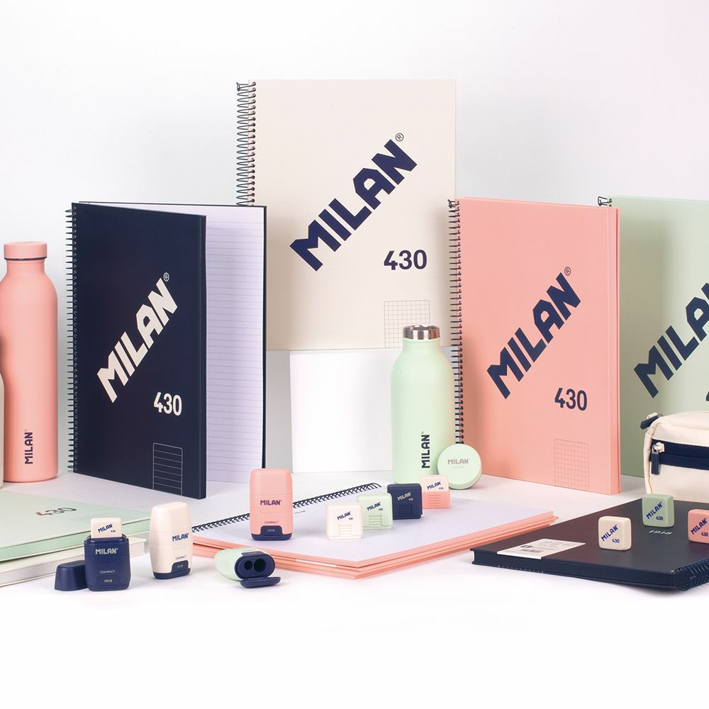 Asortyment artykułów piśmienniczych marki MILAN, w tym notatniki, butelki, temperówki i gumki do ścierania.