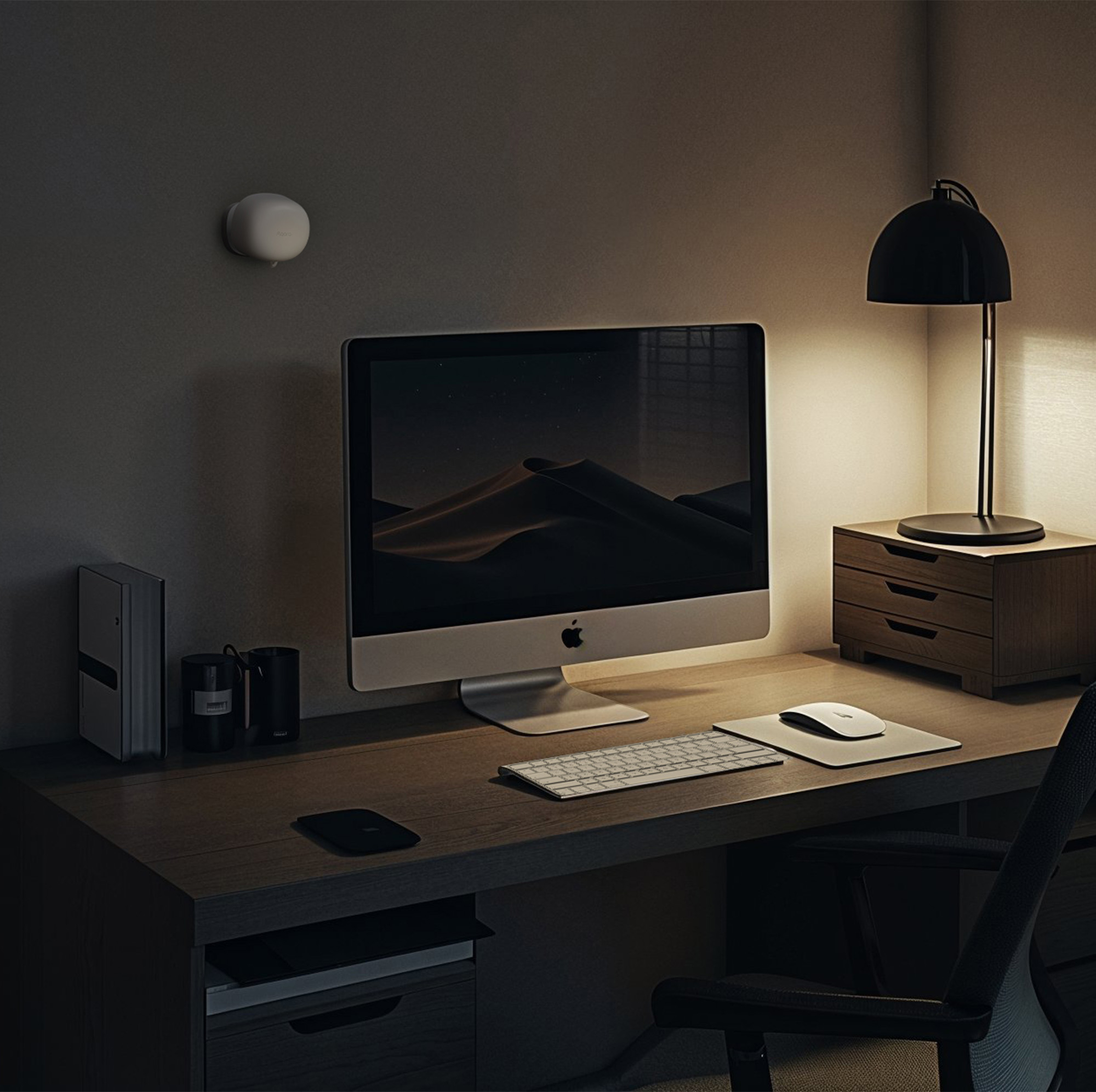 Ein Home-Office-Schreibtisch mit Computer, Lampe und Smart-Home-Gerät an der Wand, mit dunklem Thema.