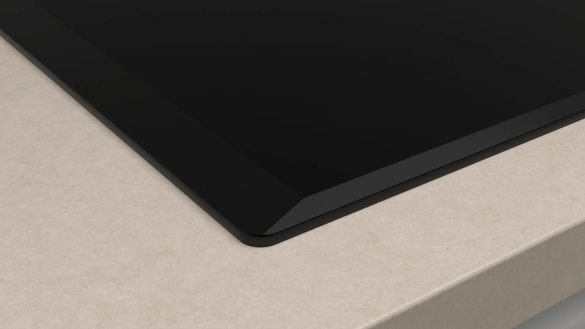 Zbliżenie błyszczącej, czarnej płyty grzewczej na jasnobeżowym blacie.