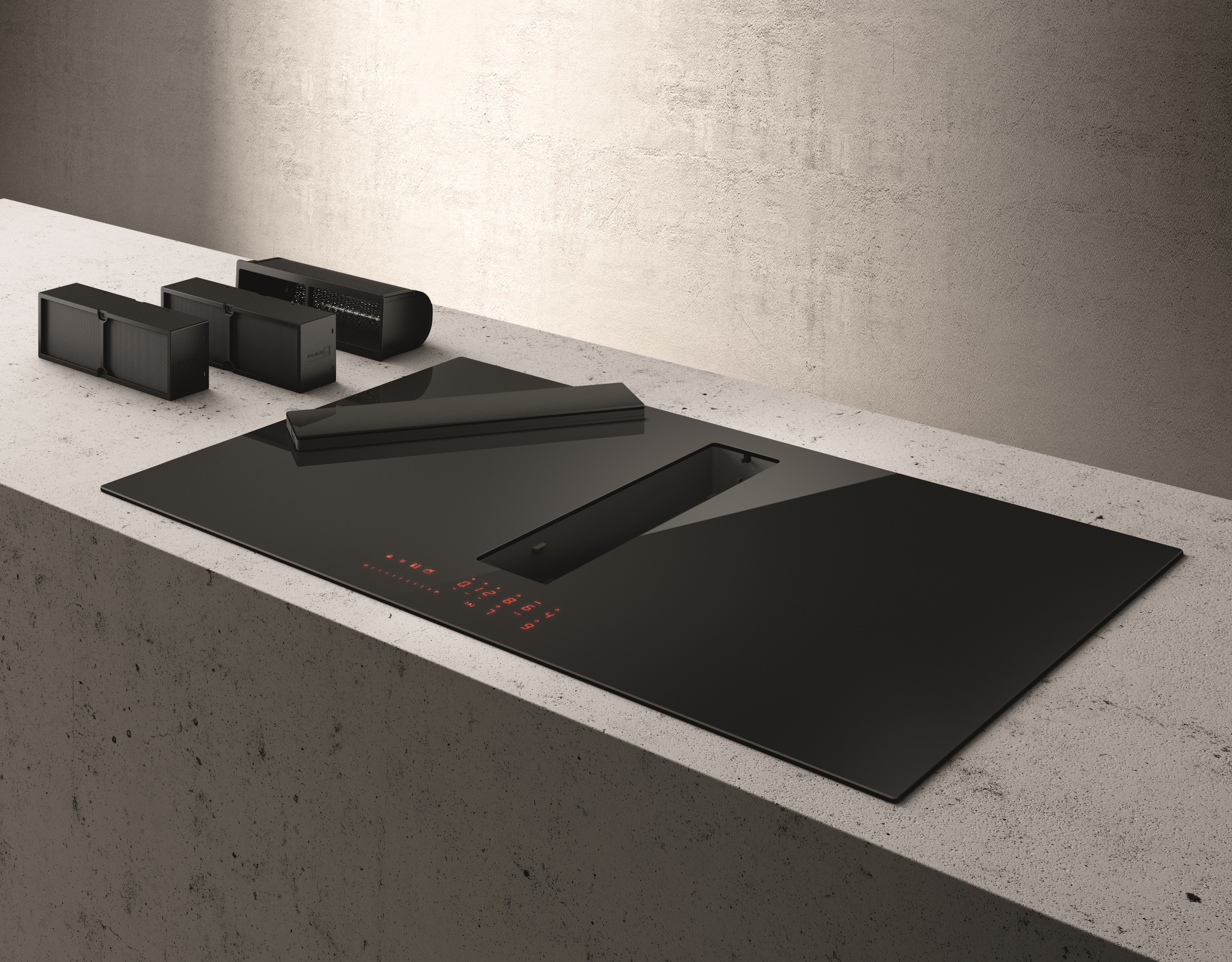 Czarna płyta grzewcza z wentylatorem i akcesoriami na jasnej betonowej powierzchni. Szare przedmioty na powierzchni. Czerwone elementy sterujące.