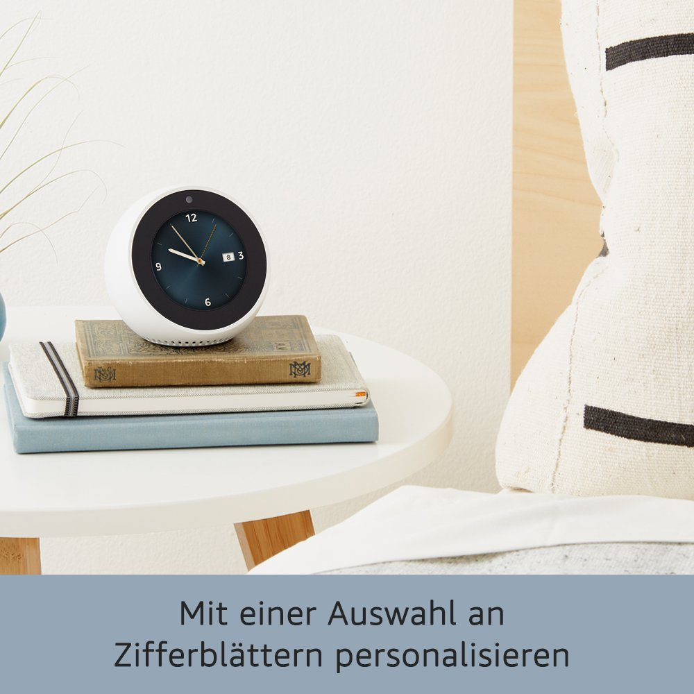 Weißer Smart Clock auf Büchern, auf einem Tisch neben einem Kissen. Text: 'Personalisieren'.