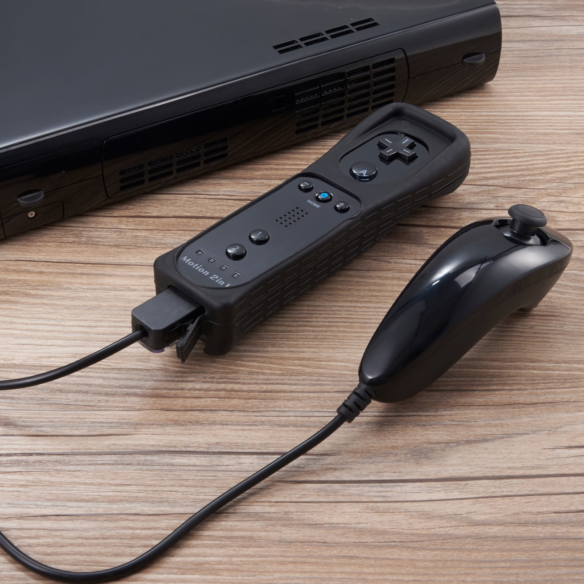 Schwarze Wii-Konsole, schwarze Wii-Fernbedienung und schwarzer Motion 2in1-Controller auf Holz.