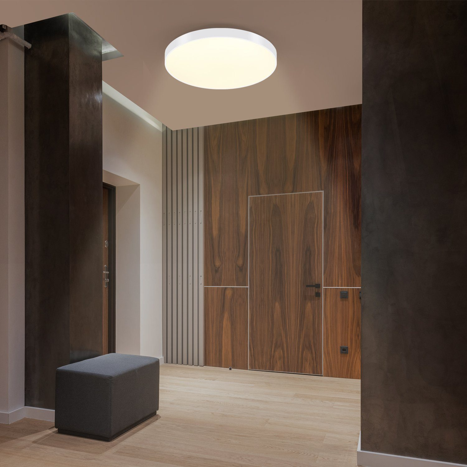 Corridoio moderno con pareti in legno, una panca grigia e una luce a soffitto rotonda. Ci sono due porte.