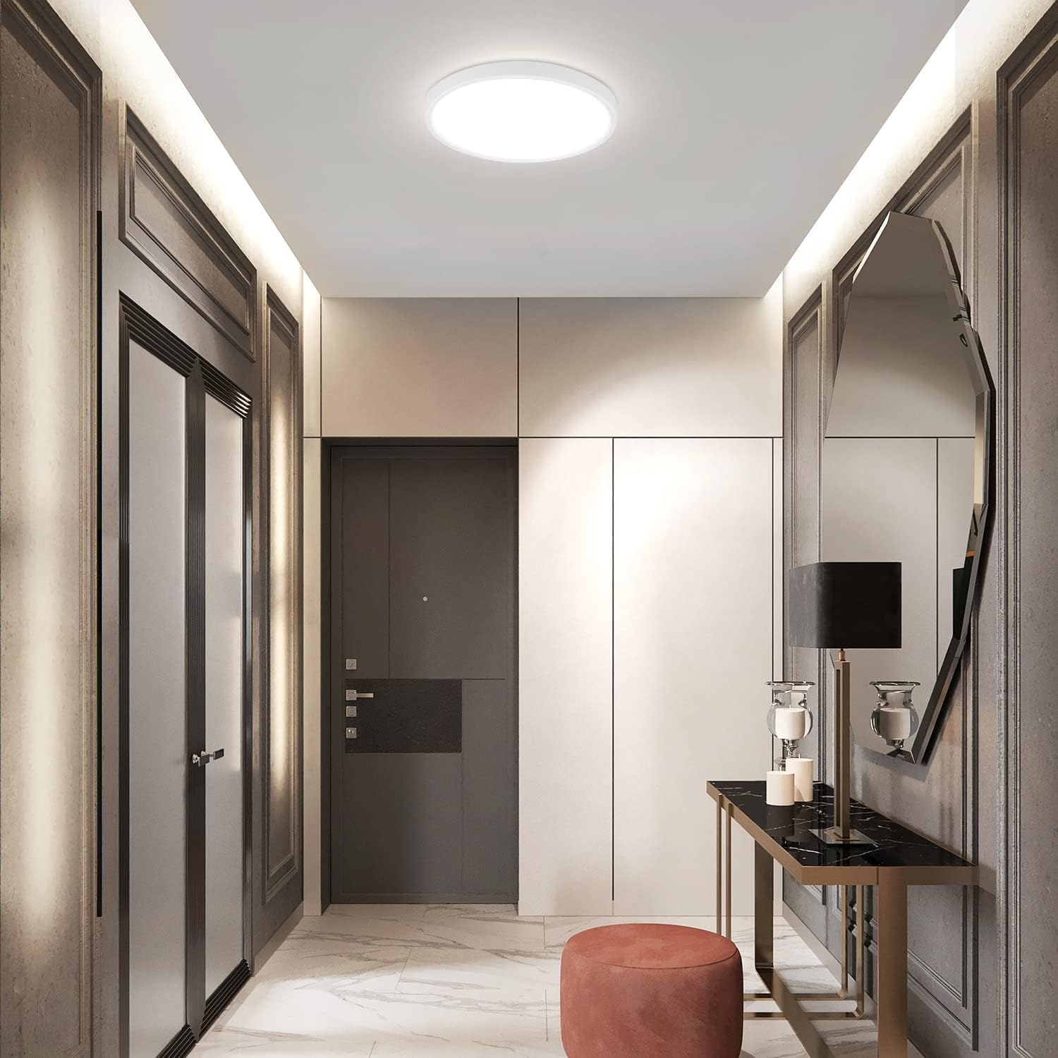 Un corridoio con una luce a soffitto bianca, pavimento in marmo e uno specchio decorativo.