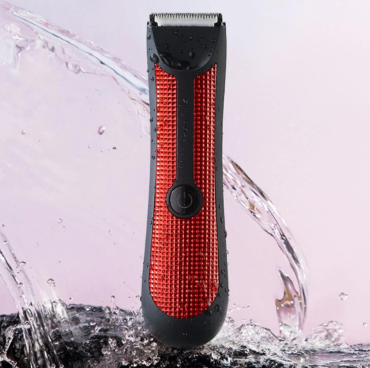 Schwarzer und roter Elektrorasierer mit Wasserspritzern. Ein Ein-Aus-Knopf ist sichtbar.