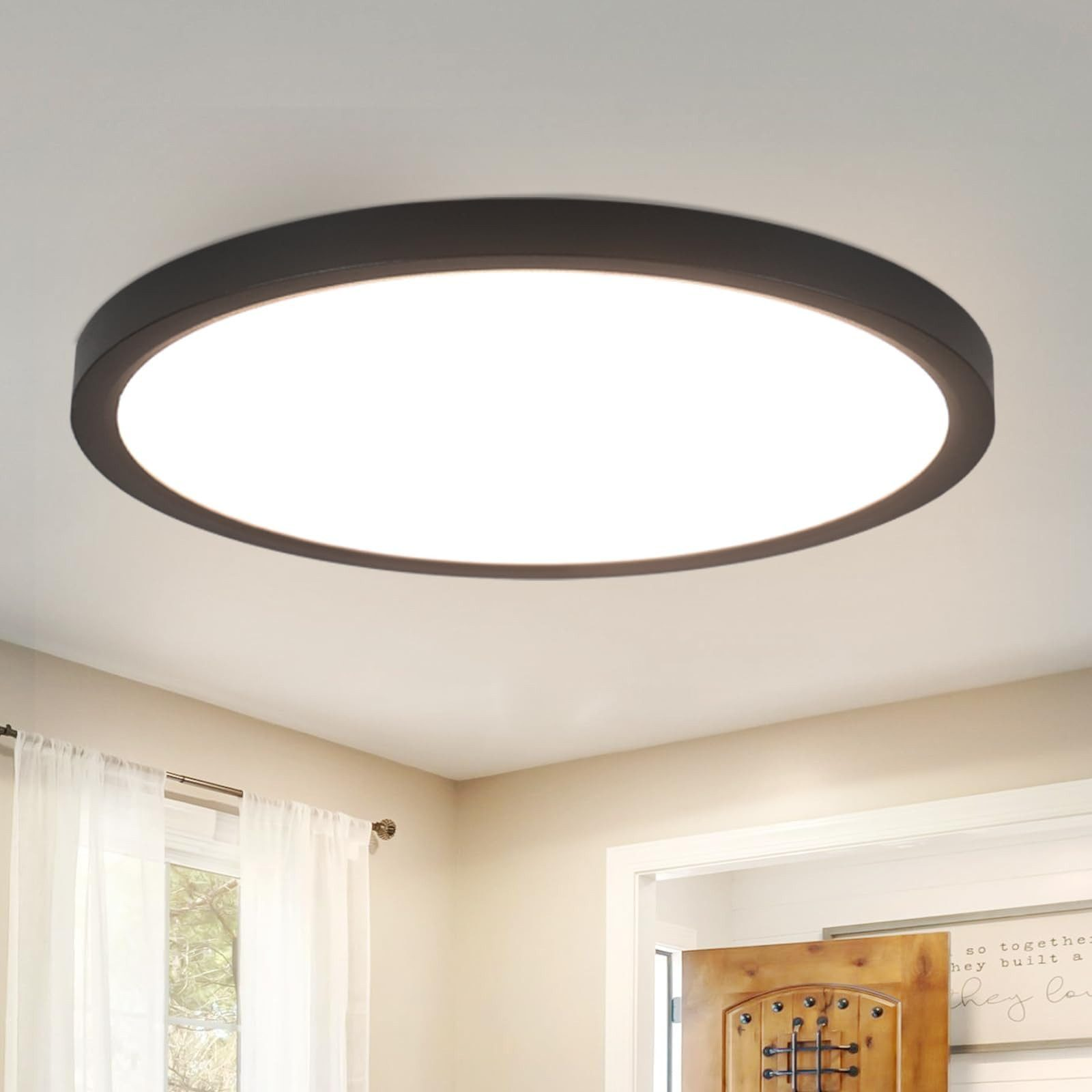 Plafoniera rotonda, cornice nera, centro bianco, installata. Stanza con soffitto bianco e pareti beige.
