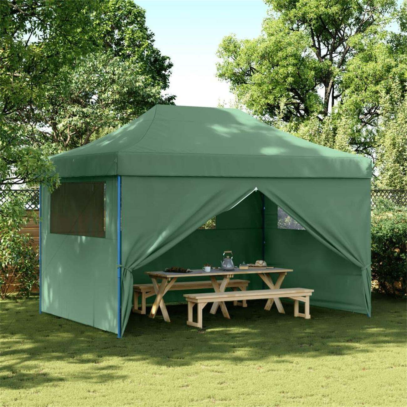 Grüner Pavillon im Garten. Tisch und Bänke. Bäume im Hintergrund.