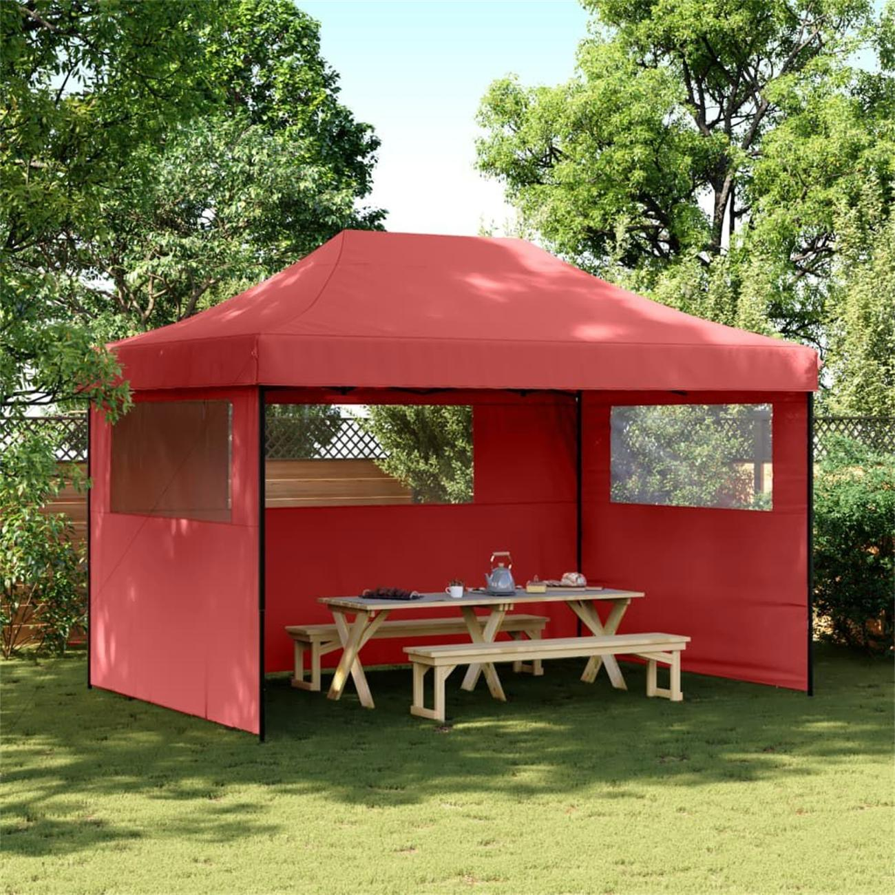 Rotes Vordachzelt mit Picknicktisch und Bänken, auf Gras gestellt.