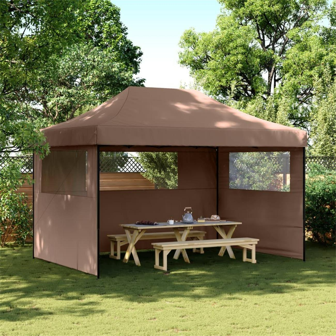 Brauner Pavillon mit Tisch und Bänken auf grünem Gras, umgeben von Bäumen.