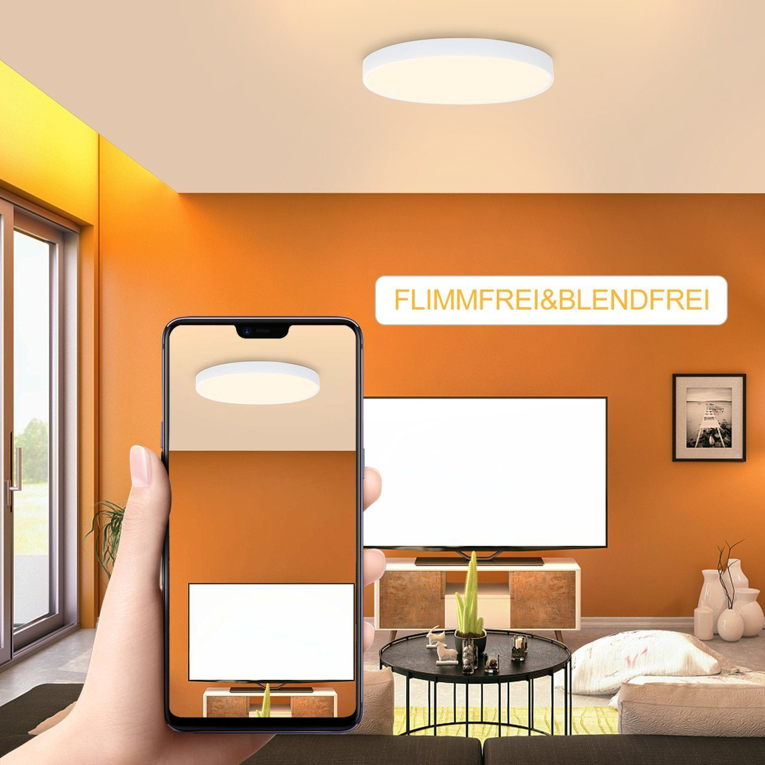 Una mano tiene in mano un telefono che mostra una plafoniera in una stanza con pareti arancioni, una TV e mobili bianchi.