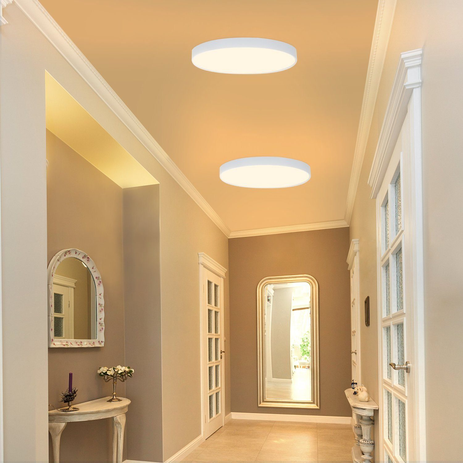 Corridoio con due luci a soffitto, porte e uno specchio.