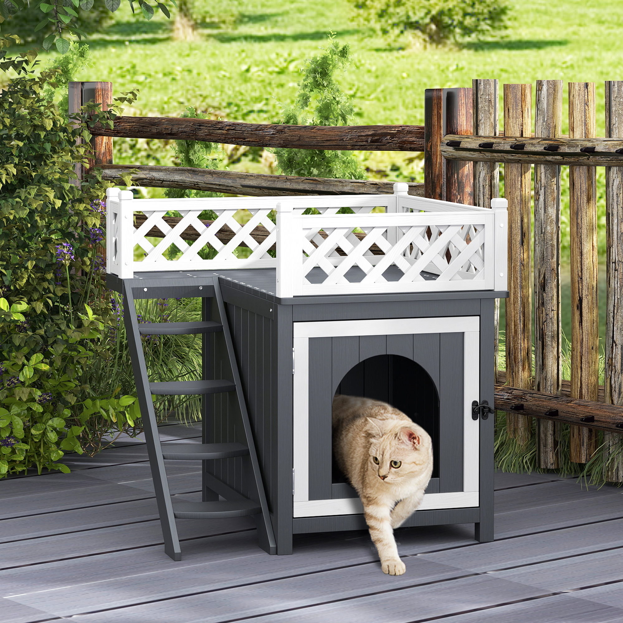 Katzenhaus mit Katze. Grau, weiß und schwarz. Holzzaun im Hintergrund.
