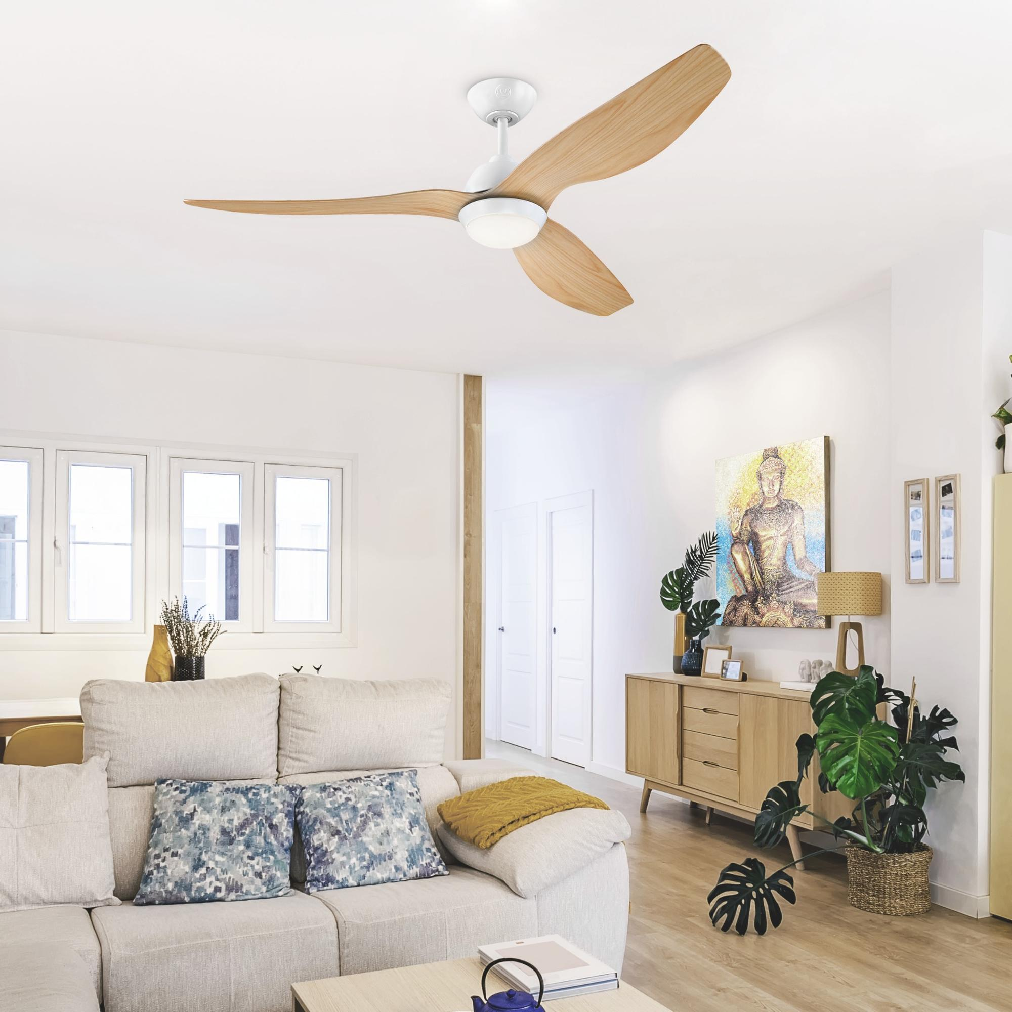 Wohnzimmer mit Deckenventilator, Sofa und Holzschrank. Ein Gemälde und Pflanzen im Hintergrund.